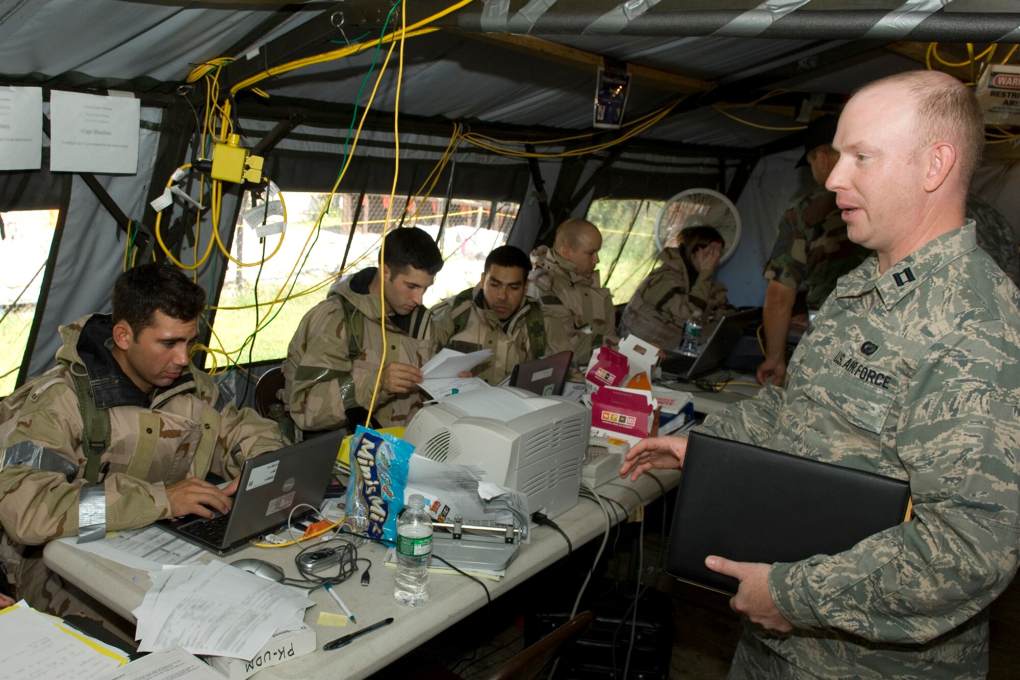 HANSCOM AFB, MASS. -- Capt. Patrick Graham, 66th Contracting Squadron specialist, speaks to contracting and financial management Airmen during a base readiness exercise here, Aug. 22. During the exercise, Airmen from Hanscom demonstrated their abilities to complete job tasks while working in a field environment. Readiness exercises help Airmen prepare for deployment. (U.S. Air Force photo by Rick Berry)
