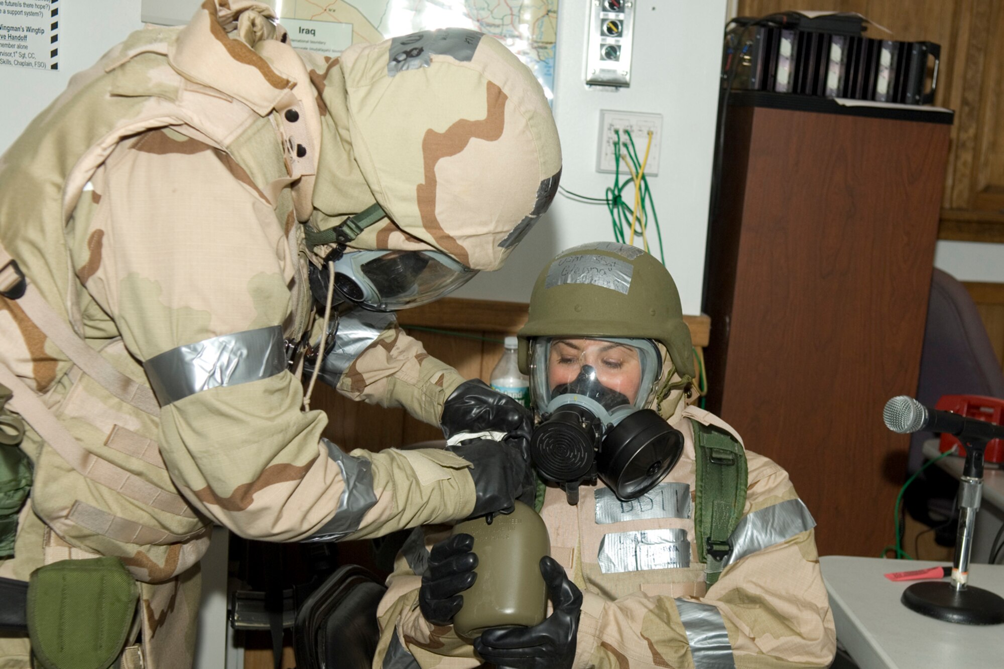 HANSCOM AFB, MASS. -- 1st Lt. Paul Cornn, 642nd Electronic Systems Squadron, helps Staff Sgt. Glenna Miller, 66th Mission Support Group, to drink water from her canteen while wearing her gas mask during a base readiness exercise here, Aug. 22. Staying hydrated while wearing heavy mission oriented protective posture gear helps prevent heat-related injuries among Airmen. During the readiness exercise, Airmen demonstrated their abilities to survive and operate in a combat environment. (U.S. Air Force photo by Rick Berry)