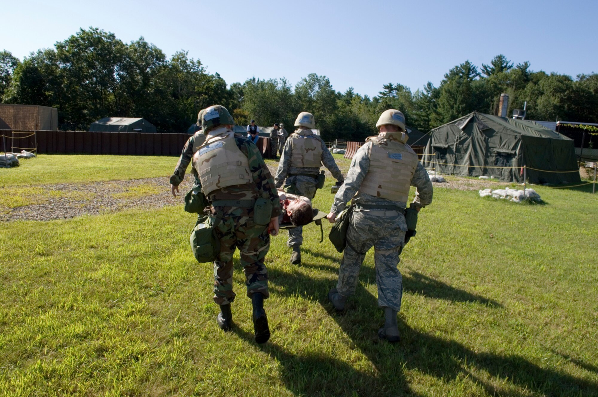 HANSCOM AFB, MASS. -- Airmen practice transporting a wounded comrade during a base readiness exercise here, Aug. 21. During the exercise, Airmen from Hanscom demonstrated their abilities to survive and operate in a combat environment. Readiness exercises help Airmen prepare for deployment. (U.S. Air Force photo by Rick Berry)
