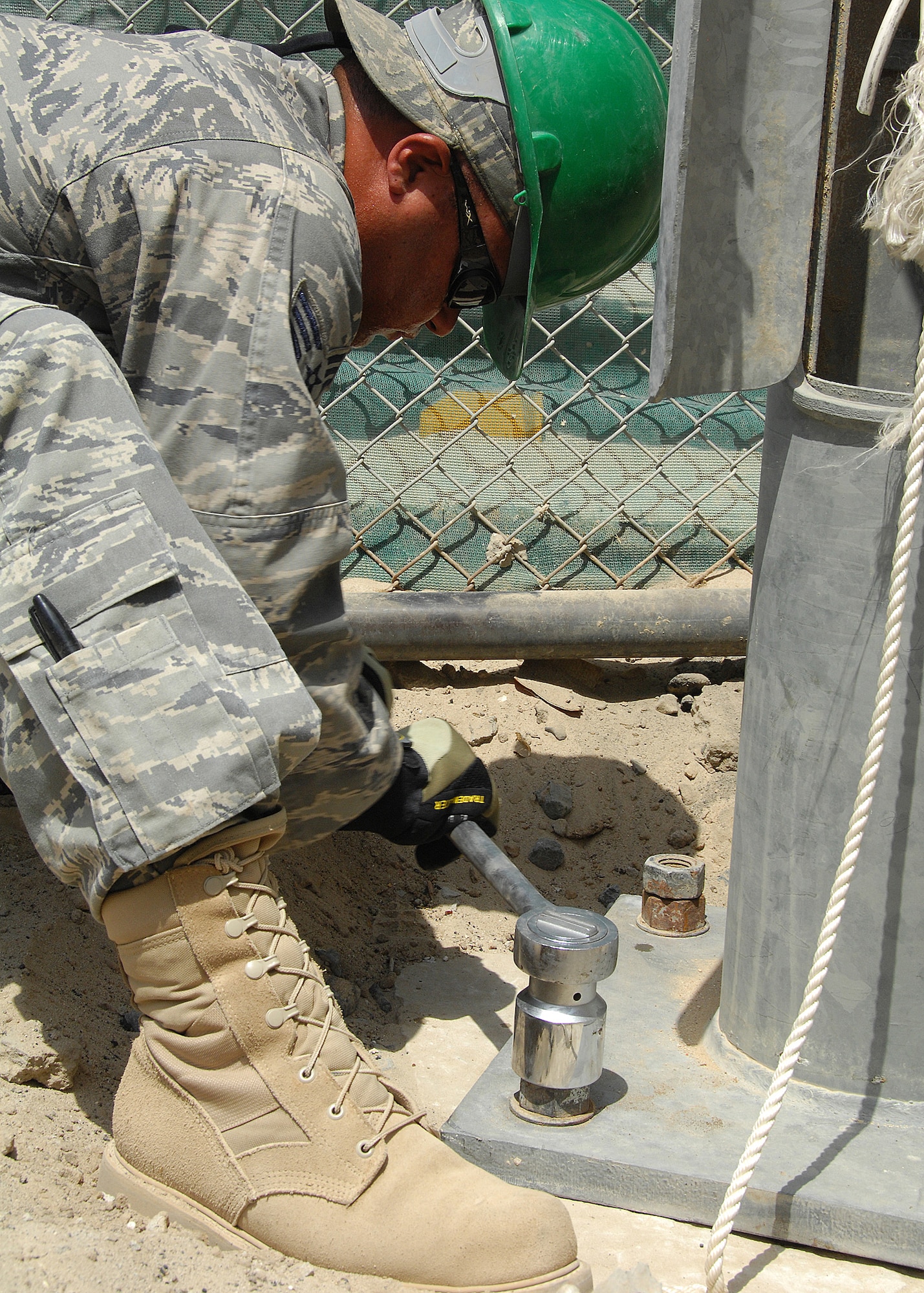 SOUTHWEST ASIA -- Senior Airman Jose Lozadacosme, assigned to the 386th Expeditionary Civil Engineer Squadron, tightens down bolts on the base of a light pole on Aug. 23 at an air base in Southwest Asia. The 386th ECES installed four new light poles on the Republic of Korea Air Force compound because of previous wind damage to the poles. The installation was a joint effort between U.S. and Korean Airmen. Airman Lozadacosme is deployed from the Puerto Rico Air National Guard. (U.S. Air Force photo/Tech. Sgt. Raheem Moore)