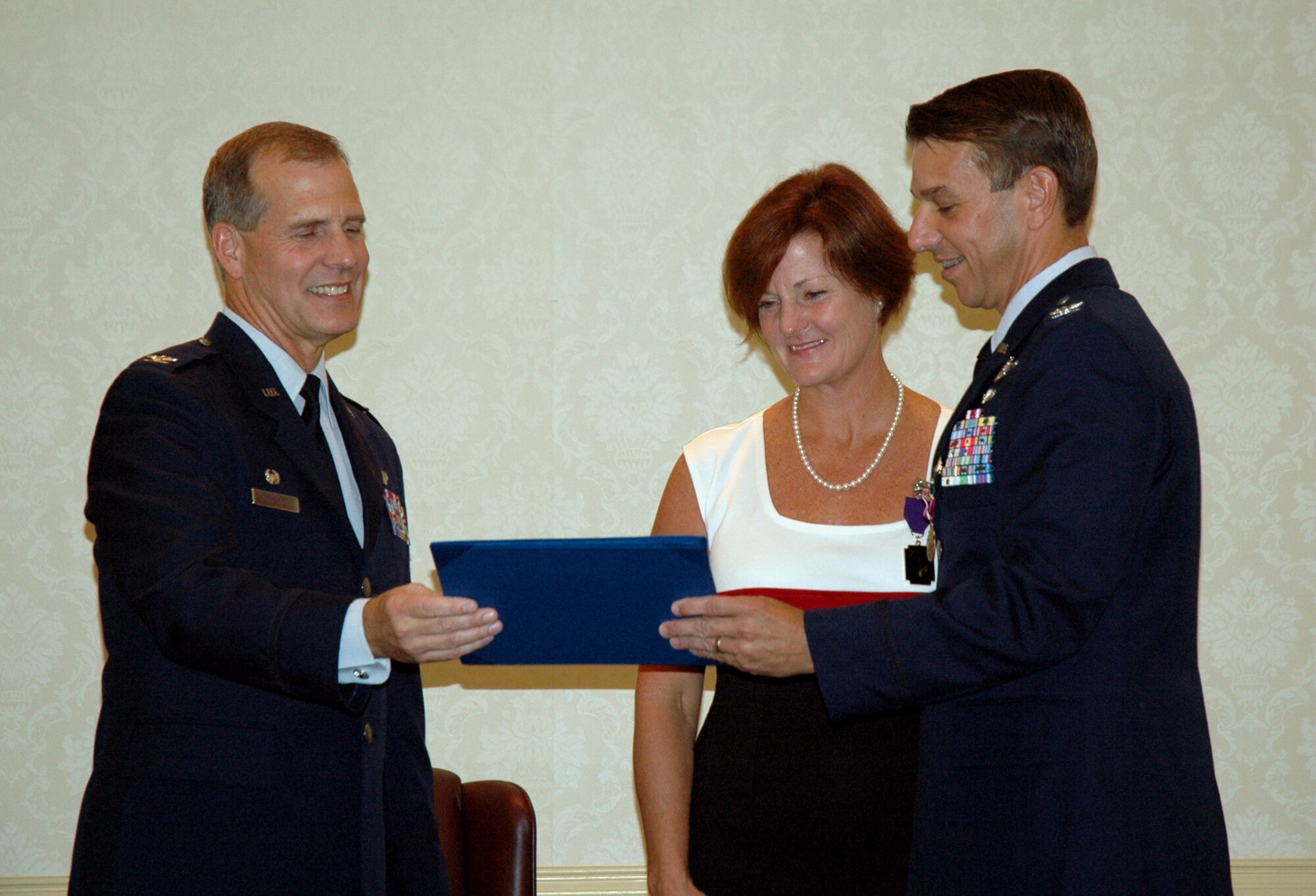 Colonel Mark Bauknight, 315th Airlift Wing Vice Commander and Colonel Timothy Wrighton, 315th Airlift Wing Commander present Col. Bauknight's wife Lesley with the Military Spouse Medal during his official retirement ceremony held here on Sunday.  Col. Bauknight retires after 23 years of military service. (U.S. Air Force photo/Staff Sgt. Jeff Kelly)