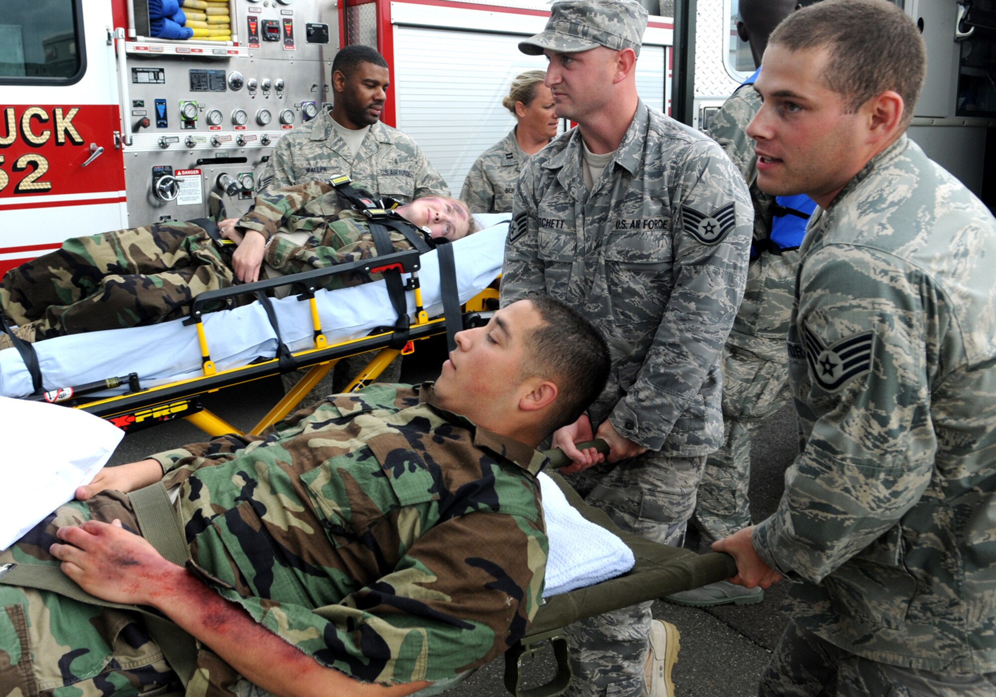 SPANGDAHLEM AIR BASE, Germany – Staff Sgts.  Joseph Fichett and Elbert Jenkins, munitions inspectors with the 52nd Equipment Maintenance Squadron, help carry Airman First Class Matthew Briseno, 52nd Medical Support Squadron, onto an ambulance after treating simulated injuries Aug. 20, 2008.  All of them were taking part in an exercise to help EMS Airmen prepare for accidents.  (U.S. Air Force photo by Staff Sgt. Logan Tuttle)