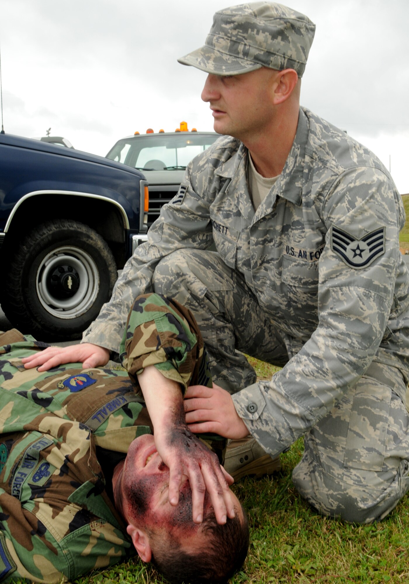 SPANGDAHLEM AIR BASE, Germany – Staff Sgt.  Joseph Fichett, a  munitions inspector with the 52nd Equipment Maintenance Squadron, treats the simulated injuries of Master Sgt. Gary Kimball, 52nd Fighter wing, Aug. 20, 2008.  Both Airmen were taking part in an exercise to help EMS Airmen prepare for accidents.  (U.S. Air Force photo by Staff Sgt. Logan Tuttle)