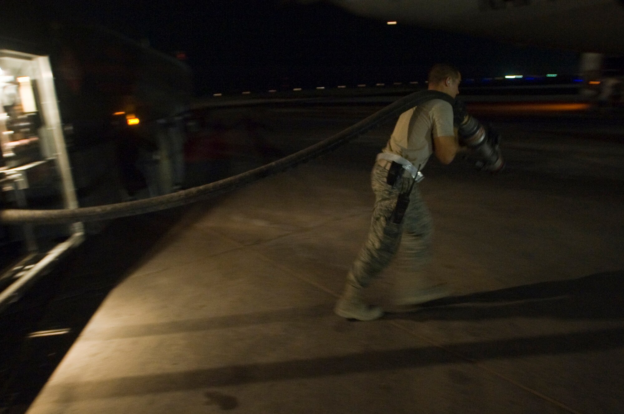 ALI BASE, Iraq -- Senior Airman Greg Crews, 407th Expeditionary Logistics Readiness Squadron fuels operator, drags a fuel hose to a Navy P-3 to issue it JP-8 fuel Aug. 22, 2008. The 407th ELRS Fuels Management Flight supports not only the Air Force, but is a critical asset for the Navy and Army providing the fuel needed 24 hours a day to ensure mission success. Crews is deployed from Hurlburt Field Air Force Base, Fla. (U.S. Air Force photo/Airman 1st Class Christopher Griffin)