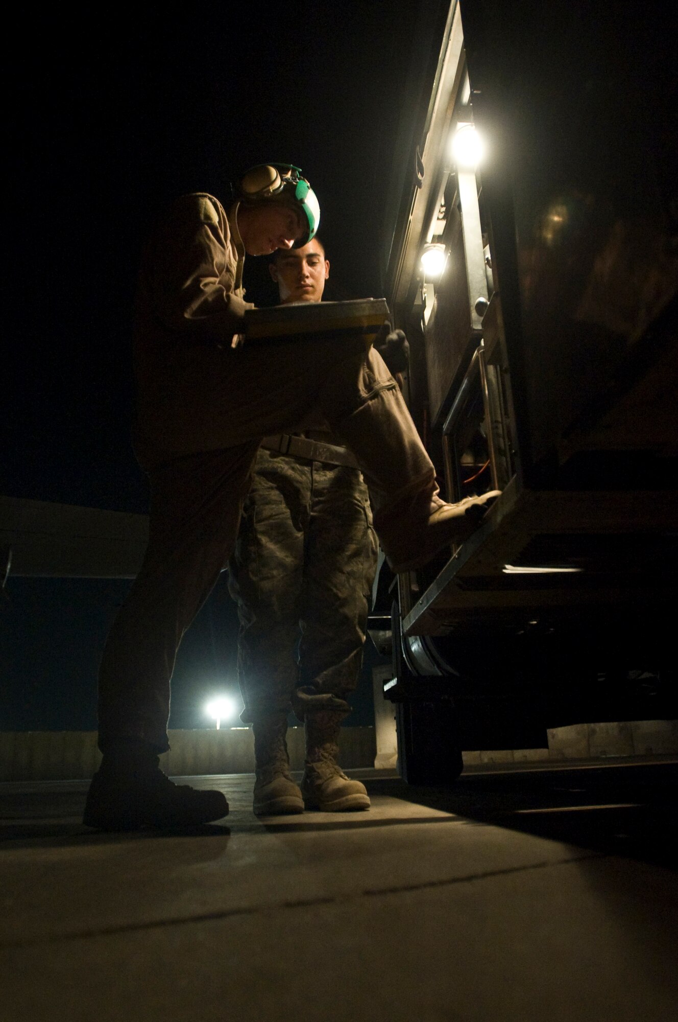 ALI BASE, Iraq -- Navy Petty Officer 3rd Class Gerard Betancourt, a P-3 anti-warfare systems operator, and Senior Airman Greg Crews, 407th Expeditionary Logistics Readiness Squadron fuels operator, sign a fuel distribution sheet Aug. 22, 2008. The 407th ELRS Fuels Management Flight supports not only the Air Force, but is a critical asset for the Navy and Army providing the fuel needed 24 hours a day to ensure mission success. They are also responsible for distributing fuel to all of the power generators here. Crews is deployed from Hurlburt Field Air Force Base, Fla. (U.S. Air Force photo/Airman 1st Class Christopher Griffin)