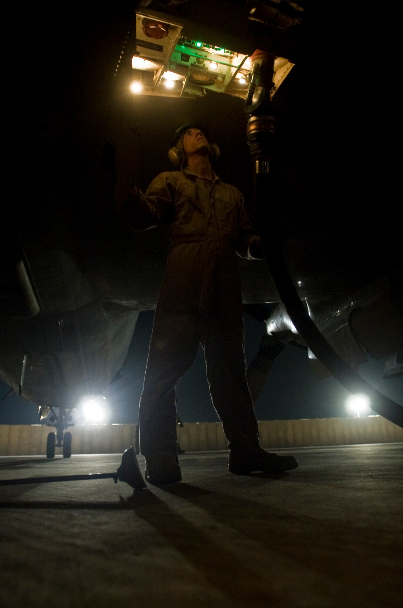 ALI BASE, Iraq -- Navy Petty Officer 3rd Class Gerard Betancourt, an anti-warfare systems operator, watches the fuel gauges on a P-3 to assure its fuel tank is full Aug. 22, 2008. The 407th Expeditionary Logistics Readiness Squadron Fuels Management Flight here supports not only the Air Force, but is a critical asset for the Navy and Army providing the fuel needed 24 hours a day to ensure mission success. They are also responsible for distributing fuel to all of the power generators here.  (U.S. Air Force photo/Airman 1st Class Christopher Griffin)
