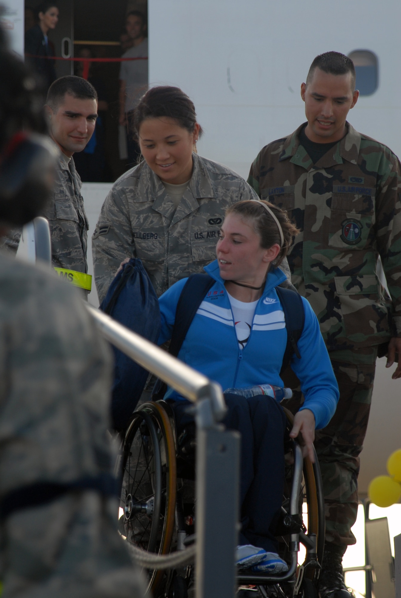 Airman 1st Class Elisa Mellberg, 718th Civil Engineer Squadron housing
maintenance, helps Amanda McGrory, world record holder in the 5,000-meter race down a ramp specially designed by members of Team Kadena to assist with wheel chair access from the aircraft on Kadena's flightline Aug. 24.  The athletes will spend the week on base in preparation for the 2008 Beijing Paralympics. (U.S. Air Force
photo/Staff Sgt. Christopher Marasky)

