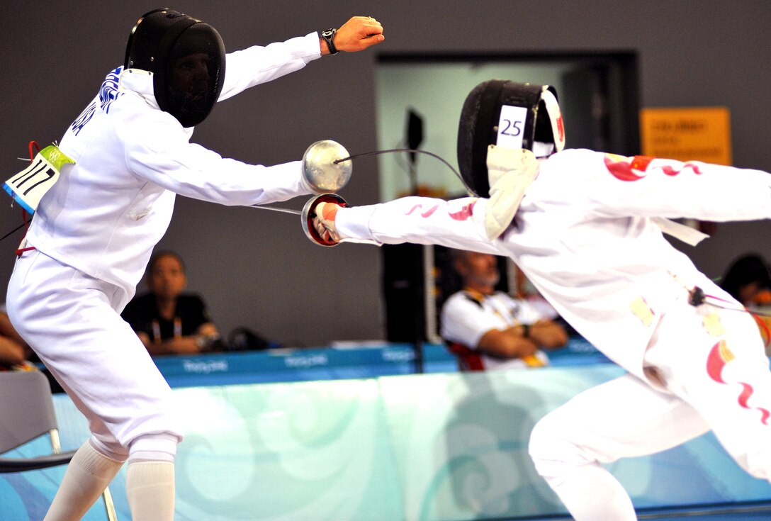 U.S. Air Force World Class Athlete Program Capt. Eli Bremer, left, scores against China's Zhon rong Cao in the epee one-touch fencing portion of the Olympic men's modern pentathlon in Beijing, Aug. 21, 2008. 