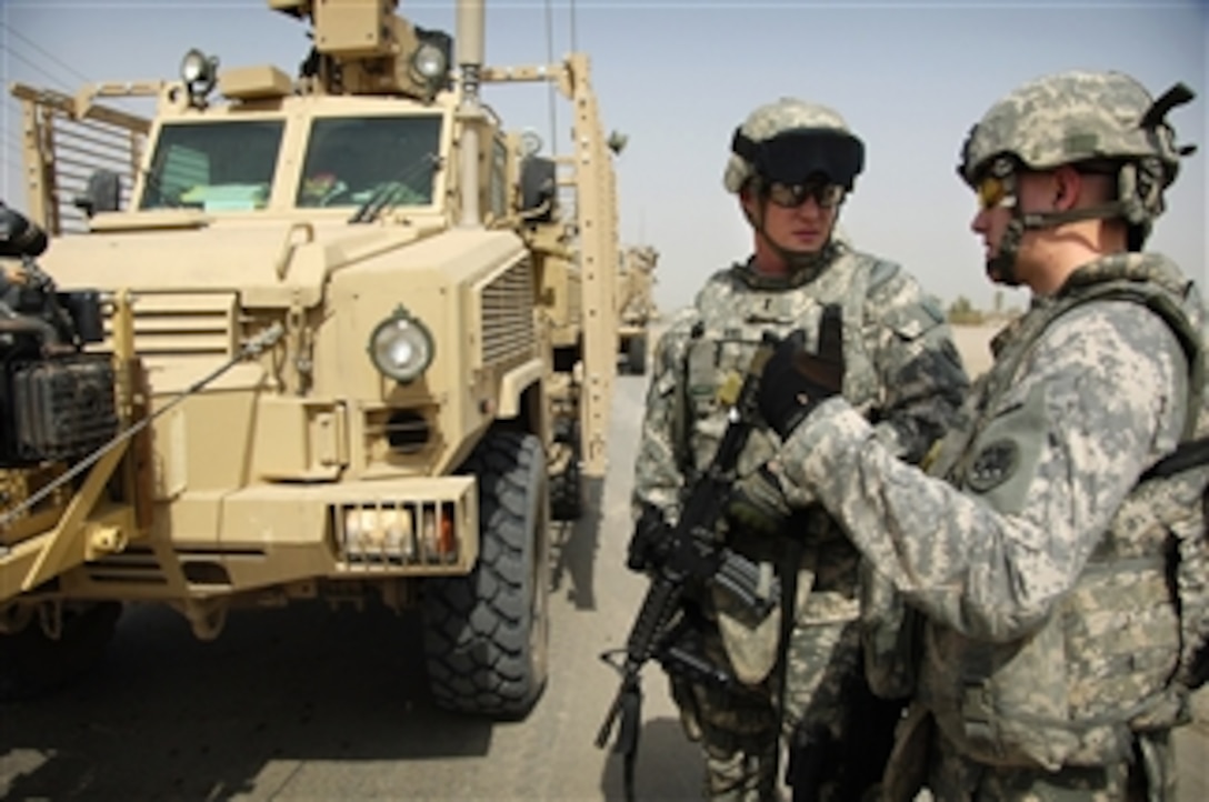 U.S. Army 1st Lt. Jonathan Kiel and 2nd Lt. Michael Cooper discuss route-clearing plans on Route Canucks in Iraq on Aug. 19, 2008.  The service members are clearing the route of obstacles for a convoy consisting of four large generators headed to designated Iraqi communities.  Kiel and Cooper are both assigned to the 848th Engineering Company, Georgia Army National Guard.  