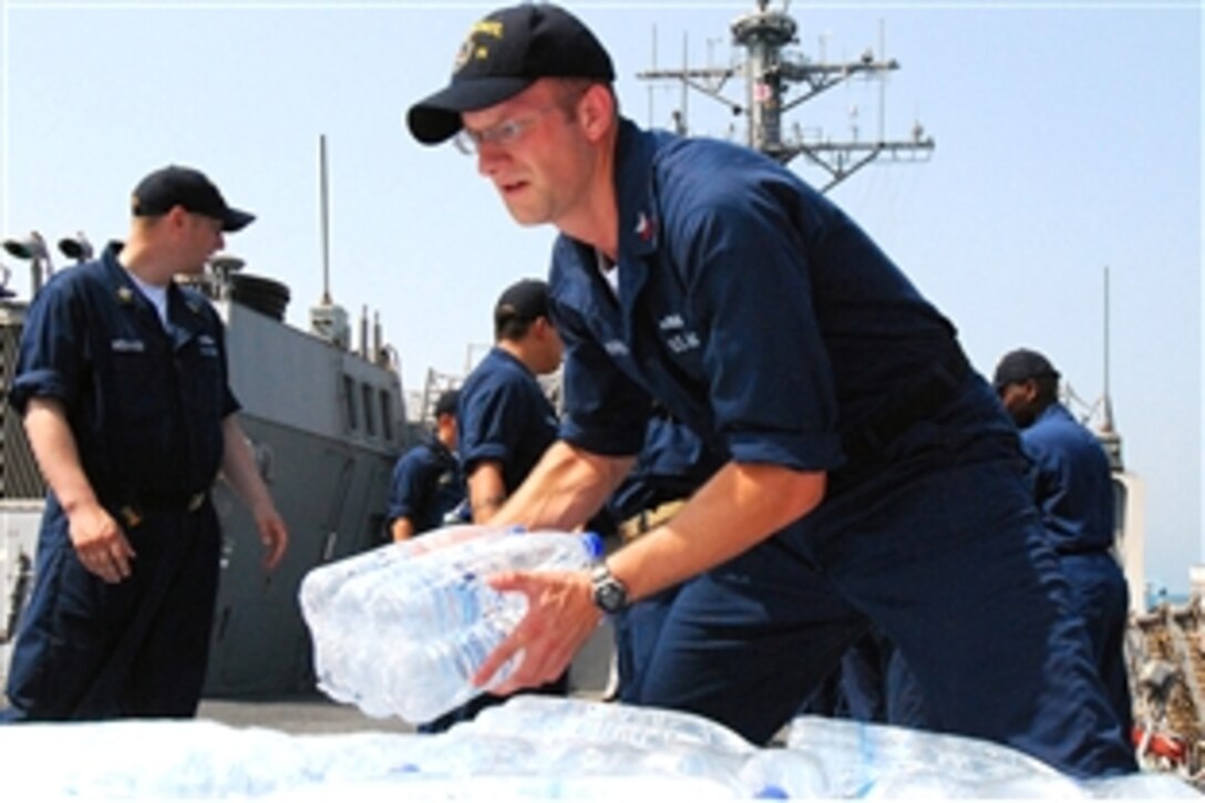 U.S. Navy Petty Officer 1st Class Jed Morris stacks bottles of water aboard the guided-missile destroyer USS McFaul, which will be included in the humanitarian supplies for the people of Batumi, Georgia, Aug. 24, 2008. The humanitarian assistance is in response to the request of the government of Georgia. Donated items include hygiene items, baby food and infant supplies. 