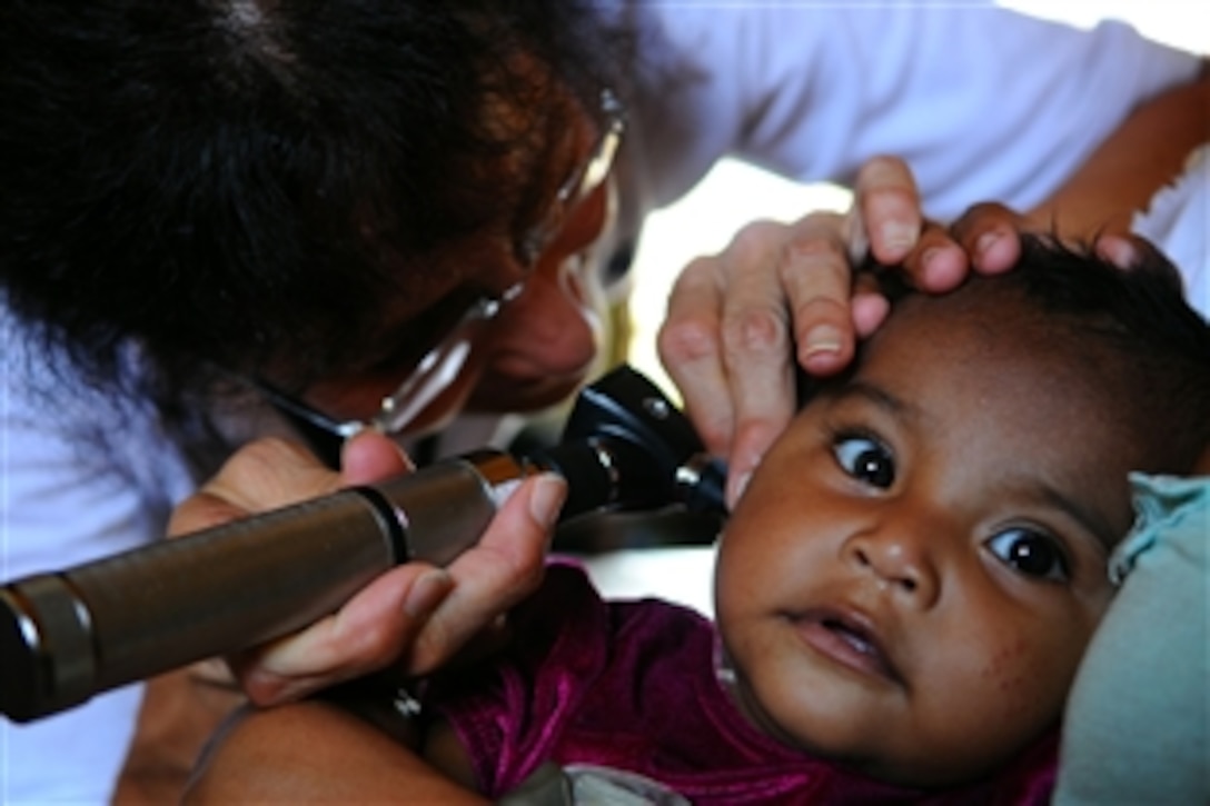 Susana Heapy, a medical volunteer from Project Hope embarked aboard the amphibious assault ship USS Kearsarge, checks a infant for an ear infection during an exam at the Juan Comenius High School medical clinic, Puerto Cabeza, Nicaragua, Aug. 18, 2008. Kearsarge is supporting the Caribbean phase of Continuing Promise 2008, an equal-partnership mission with the United States, Canada, the Netherlands, Brazil, Nicaragua, Panama, Colombia, Dominican Republic, Trinidad, Tobago and Guyana.