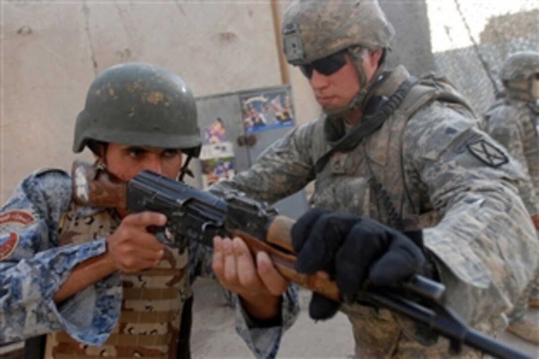 U.S. Army Staff Sgt. Nathan Camp directs an Iraqi national policeman's rifle to cover his sector of fire during room clearance training, Aug. 14, 2008, in the Jaza'ir community of southern Baghdad. Camp is attached to the 1st Brigade Combat Team, 4th Infantry Division, Multi-National Division - Baghdad, in support of Operation Iraqi Freedom. Camp is also a squad leader with Company C, 3rd Platoon, 2nd Battalion, 4th Infantry Regiment.