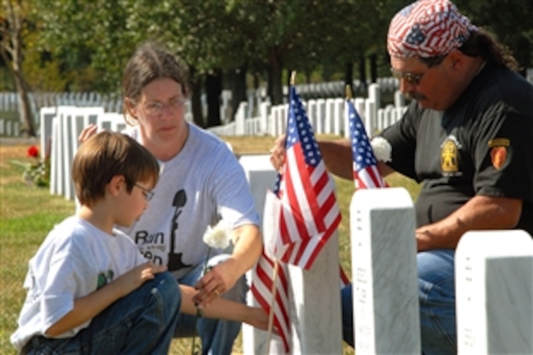 Dakota Linck, 9, left, his mother Debi, and father, Rick, place carnations at the gravesite of their brother and son, Army Staff Sgt. Henry W. Linck, in Arlington National Cemetery, Aug. 24, 2008. The Lincks traveled to Washington from Lebanon, Tenn., to participate in the final day of "Run for the Fallen," a memorial event honoring troops killed in Operation Iraqi Freedom. The run began in California on Flag Day, June 14, 2008. 