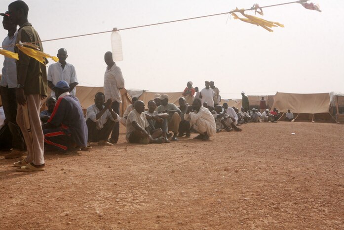 A community of Sudanese refugees waits to be seen by coalition doctors during a medical engagement in western al-Anbar province, Iraq, Aug. 25. The Sudanese refugees originally came to Baghdad, Iraq, approximately 20 years ago to pursue a better education and occupation to help their families. According to members of the community, after the fall of Saddam Hussein in 2003, the people fled to Jordan in fear of violence, only to be forced back to Iraq.  Coalition forces and Iraqi Security Forces make regular visits to the community to assist the refugees until they are relocated to a more established area in the near future.::r::::n::