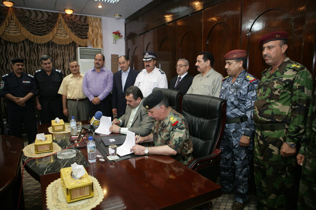 Gov. Ma’amoon Sami Rashim Alawi, al-Anbar’s provincial governor and Maj. Gen. Murthi Mush’hen Almhalawi, commanding general, al-Anbar Iraqi Security Forces, sign a Command and Control Memorandum of Understanding accepting control of security at the Provincial Governance Center in Ramadi, Iraq, Aug. 26. Gov. Ma’amoon and Maj. Gen. Murthi signed the document in preparation for total Provincial Iraqi Control scheduled for the near future.  (U.S. Marine Corps photograph by Cpl. Erin A. Kirk/Released)