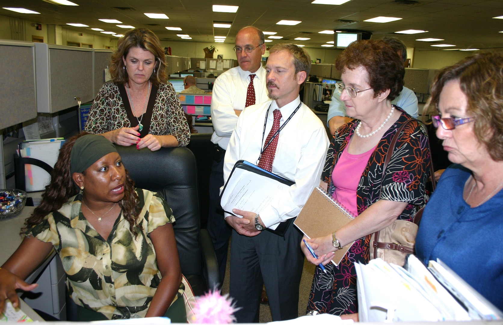 Tonya Harris (sitting), Air Force Personnel Center, briefs visitors from the U.S. Department of State's Bureau of Human Resources on the various Web-based technologies employed at AFPC's 24-hour Air Force Contact Center. The seven-member team visited AFPC recently to learn the many technological initiatives that have been undertaken to deliver personnel services to Air Force customers worldwide. (U.S. Air Force photo by Richard Salomon)