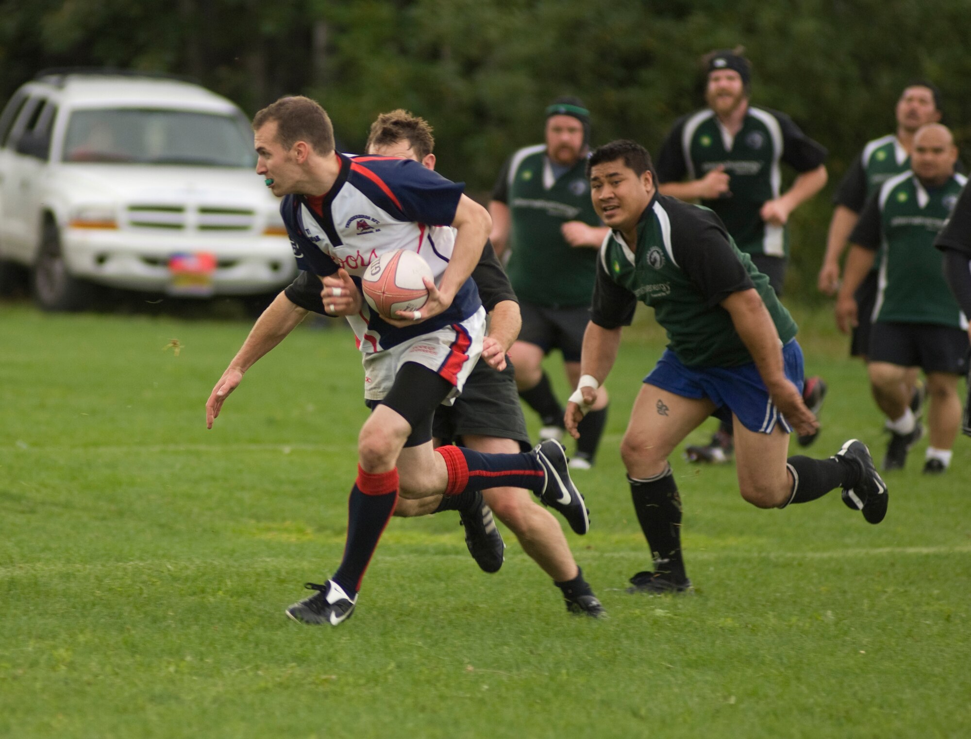 ANCHORAGE, Alaska -- Brandon Cavalieri, 381st Intelligence Squadron, runs away from defenders of the Spenard Dragons during the championship game at Davis Field Aug. 23. The team won the championship game 30-12, finishing off an unbeaten season. (U.S. Air Force photo/Airman 1st Class David Carbajal)