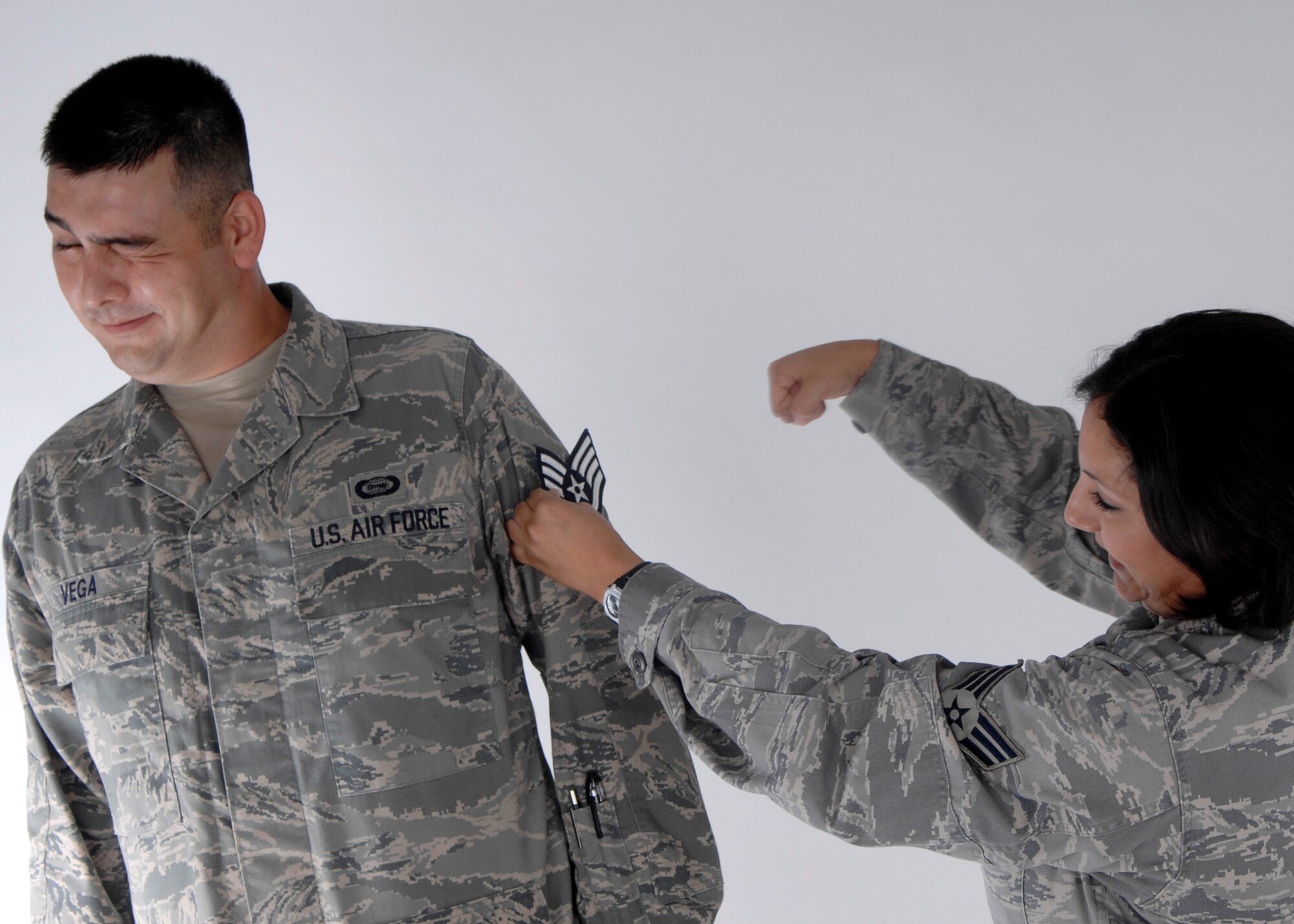 Senior Airman Sonia Vega tacks on her husband, Senior Airman John Vega's new staff sergeant stripes after the promotion results were released Aug. 20.  The Senior Airmen Vegas were high school sweet hearts who have been married for more than four years and have two sons. (U.S. Air Force photo by Airman 1st Class Joanna M. Kresge) 