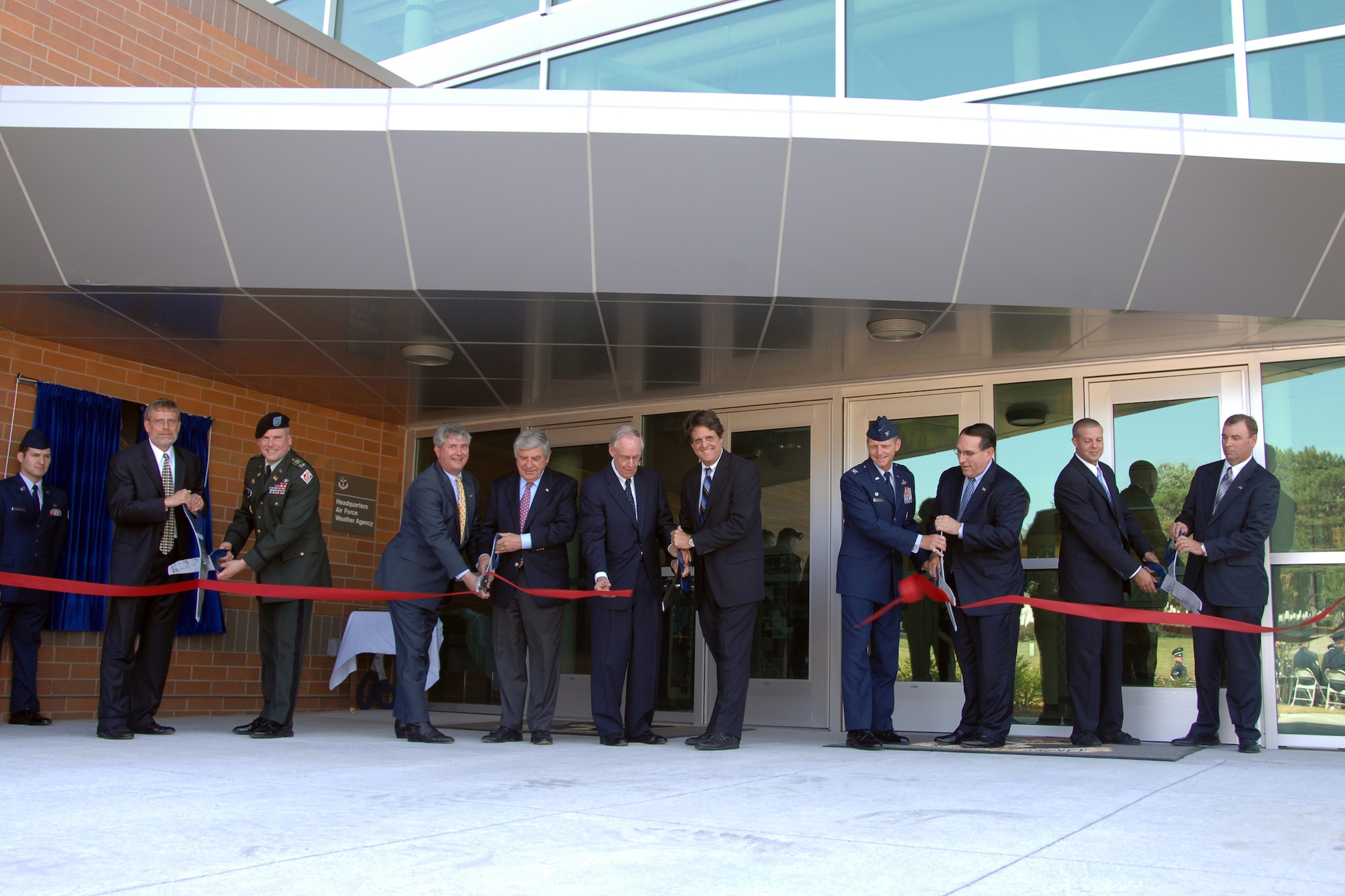 OFFUTT AIR FORCE BASE, Neb. -- Mr. Ken Hahn, president of Kenneth Hahn Architects, Army Col. David Press, U.S. Army Corps of Engineers Omaha District, Mr. Dean Mathisen, from Representative Lee Terry's office, U.S. Senator Ben Nelson, Retired Gen. Thomas S. Moorman Jr., Mr. Robert Moorman, Col. John Murphy, Air Force Weather Agency commander, Dr. Fred P. Lewis, director of Air Force Weather, Mr. Michael Backes, from U.S. Senator Chuck Hagel's office, and Mr. Joseph Lempka, Kiewit Building Group, cut the ribbon officially dedicating AFWA's new $30-million headquarters building here Aug. 22. The new building was dedicated to Lt. Gen. Thomas S. Moorman and is one of Air Combat Command’s first Leadership in Energy and Environmental Design green rated facilities. (U.S. Air Force Photo by Kevin Schwandt)