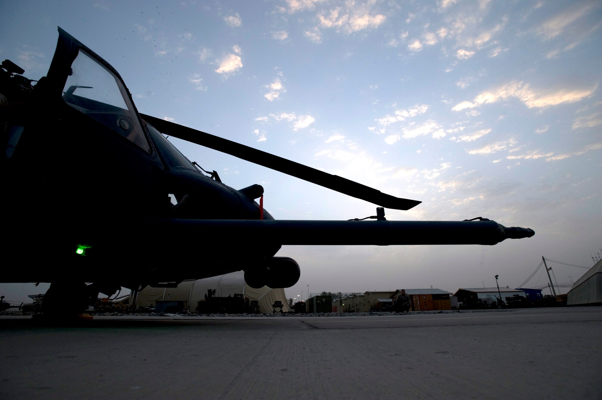 An HH-60 Pave Hawk combat search and rescue helicopter sits on the flightline as maintenance crews prepare it for a mission Aug. 10 at Kandahar Air Base, Afghanistan. The crews flying the HH-60s are supporting coalition and Afghan forces by landing in hostile areas to recover casualties and fly them to medical facilities for treatment. (U.S. Air Force photo/Master Sgt. Keith Brown)