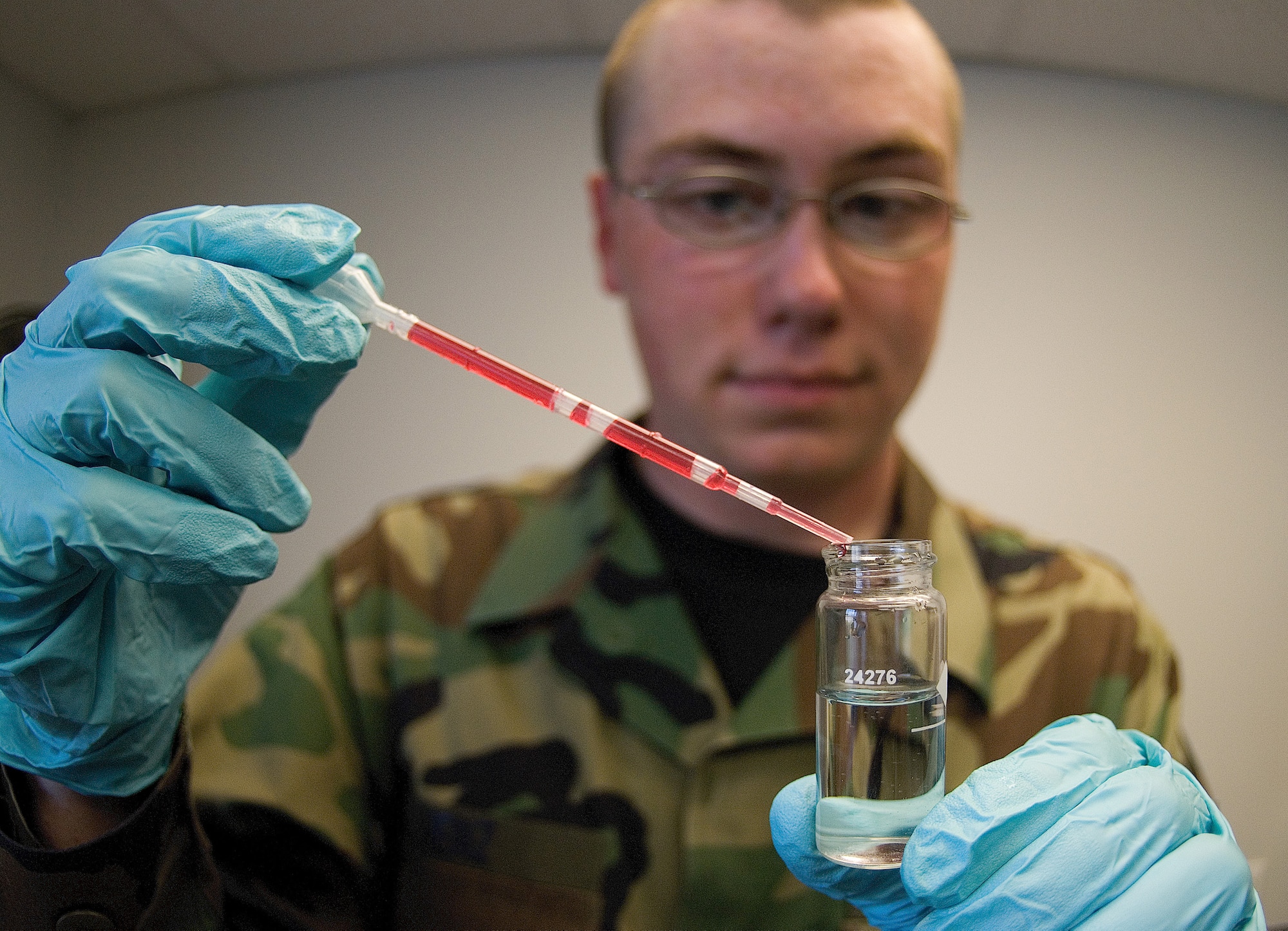 DOVER AIR FORCE BASE, Del. – Airman 1st Class Matthew Henz, 436th Aerospace Medicine Squadron Bioenvironmental Engineering technician, places a pipette of phenol red, a buffer solution, into a glass vial to test the pH level of the water. BEEs collect samples to detect and identify hazards around the base. (U.S. Air Force photo/Roland Balik) 