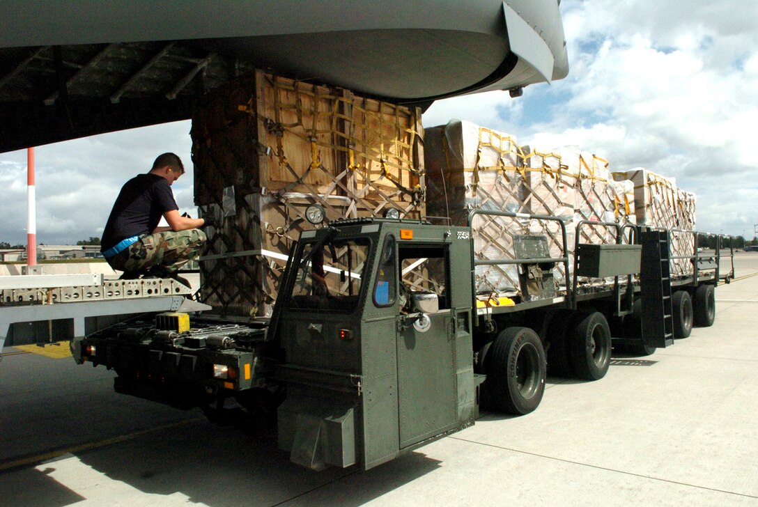 Airmen from the 723rd Air Mobility Squadron move humanitarian supplies into position for loading in support of the humanitarian mission to Georgia Aug. 26 at Ramstein Air Base, Germany. Twenty-eight Soldiers from the 66th Transportation Company and the 39th Transportation Battalion, and Airmen from the 723rd Air Mobility Squadron worked 36 hours to palletize more than 75,000 pounds of emergency shelter items and medical supplies which include tents, blankets, bedding, hygiene items, clothing, beds, cots, and medical supplies in order to support this mission. (U.S. Air Force photo/Capt. Bryan Woods)