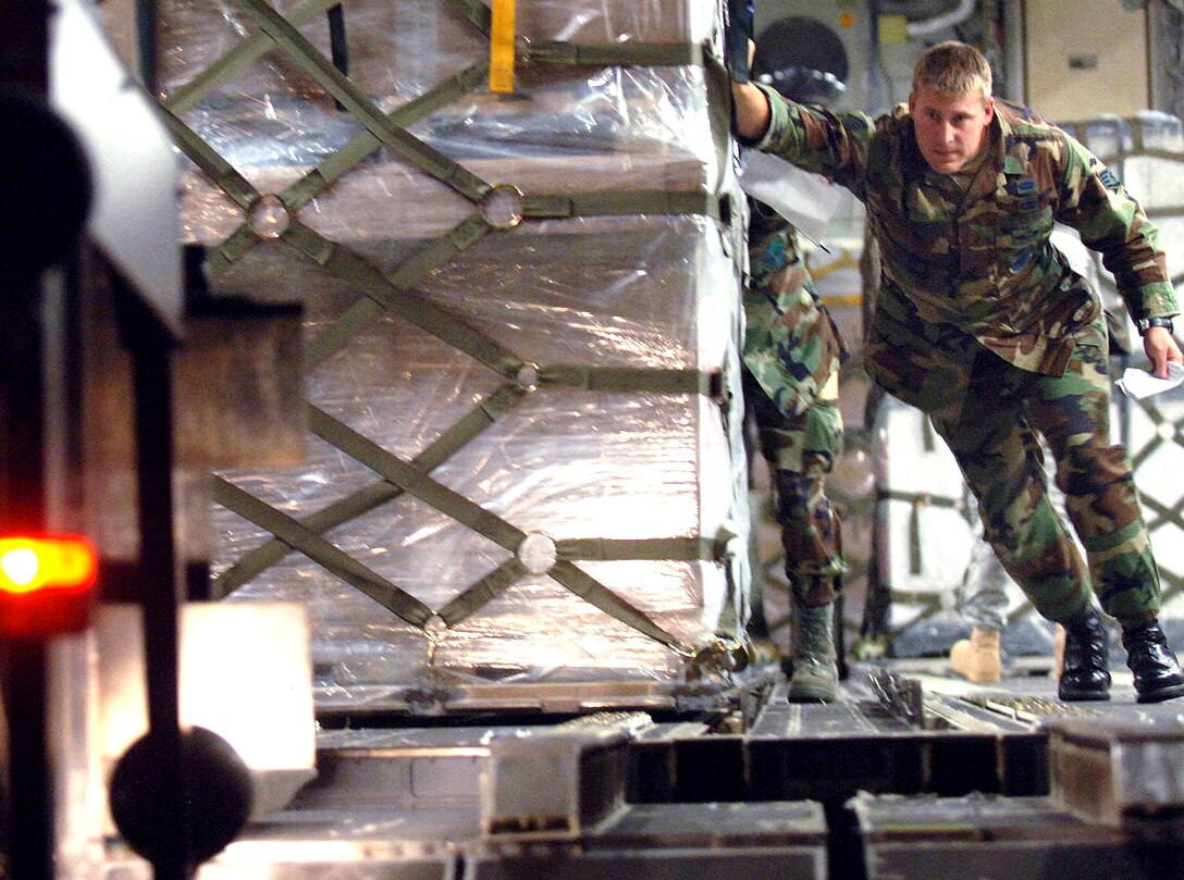 Staff Sgt. Chris Broegemueller helps push out the first of 16 pallets aboard a C-17 Globemaster III Aug. 13 at Sembach Air Base, Germany. The humanitarian assistance delivery consisted of $1 million in U.S.-donated medical supplies, blankets, sleeping bags and bed sheets for the people of the Republic of Georgia. The delivery was a joint service effort between Airmen representing both U.S. Air Forces in Europe and Air Mobility Command, as well as U.S. Army Europe Soldiers. Sergeant Broegemueller is an aerial transporter assigned to the 86th Airlift Wing's Contingency Response Group. (U.S. Air Force photo/Master Sgt. Scott Wagers) 