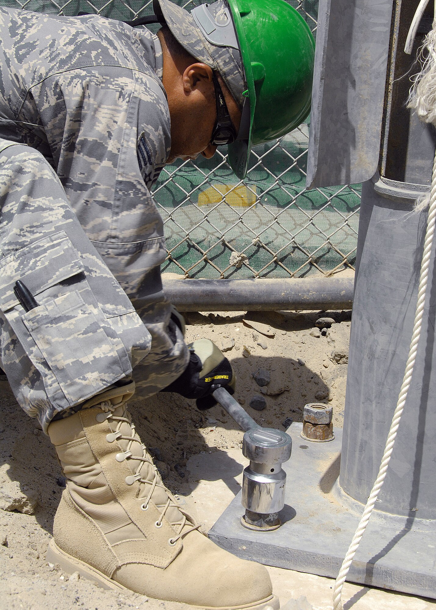 Senior Airman Jose Lozadacosme tightens down bolts on the base of a light pole on Aug. 23 at an air base in Southwest Asia.  The installation replaced wind-damaged poles in the South Korean air force compound, and was a joint effort between U.S. and South Korean Airmen. Airman Lozadacosme is deployed from the Puerto Rico Air National Guard, and and he is assigned to the 386th Expeditionary Civil Engineer Squadron. (U.S. Air Force photo/Tech. Sgt. Raheem Moore) 