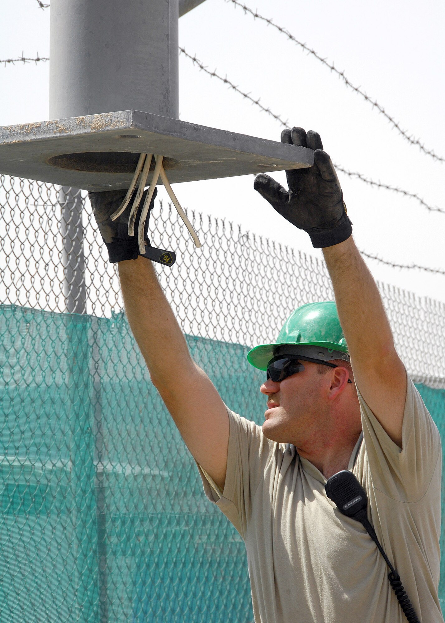 Master Sgt. Steven Gaskill steadies a light pole while it's lifted over a fence Aug. 23 at an air base in Southwest Asia. The installation replaced wind-damaged poles in the South Korean air force compound, and was a joint effort between U.S. and South Korean Airmen. Sergeant Gaskill is deployed from the New Jersey Air National Guard, and he's assigned to the 386th Expeditionary Civil Engineer Squadron,  (U.S. Air Force photo/Tech. Sgt. Raheem Moore)