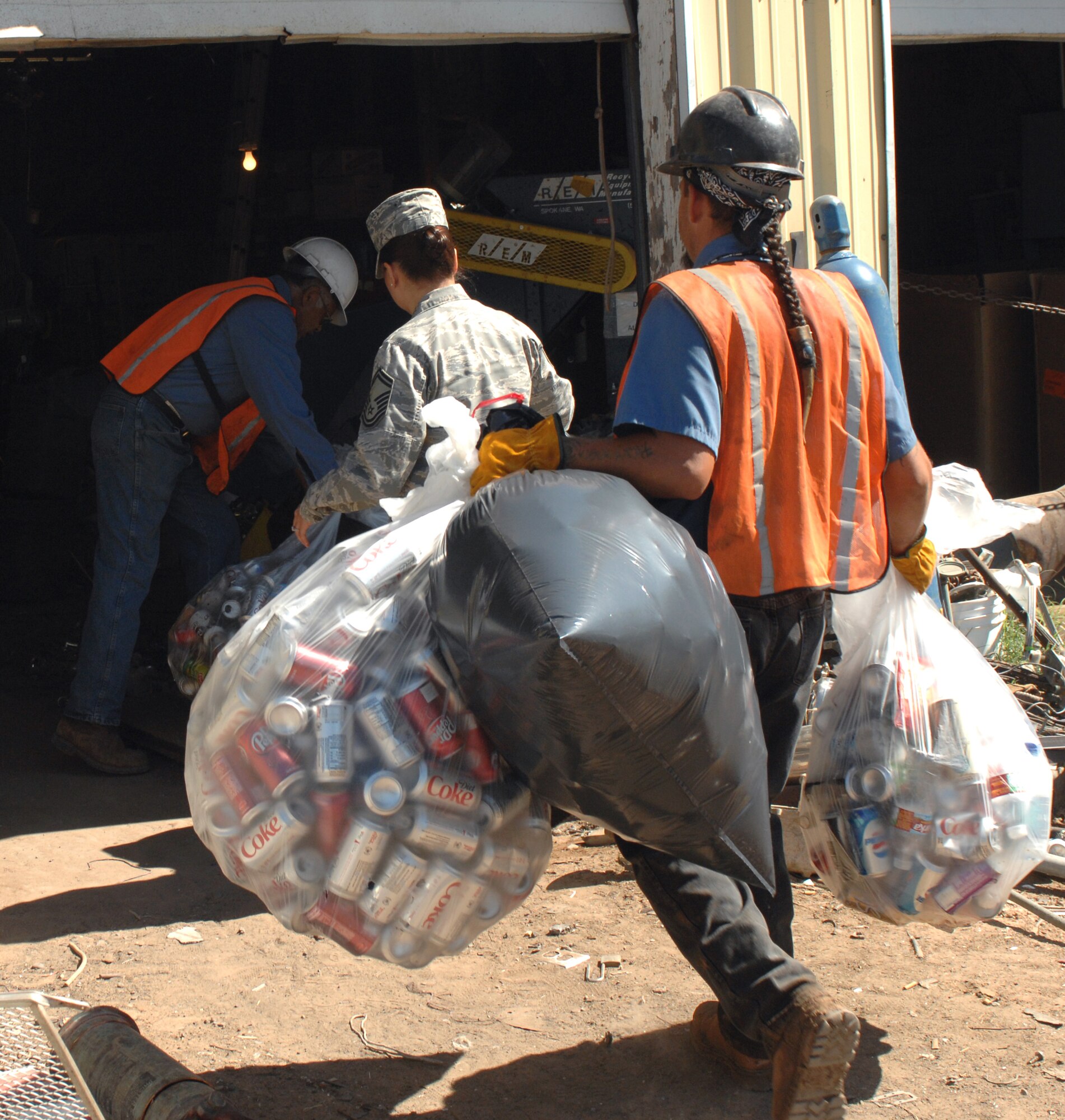 CANNON AIR FORCE BASE, N.M. - Airmen and workers from Ed's Recycling Center weigh in the amount of cans collected from Cannon's local Air Force Sergeant's Association, Chapter 55. The cans weighed in at 103 pound, providing a donation of $61.88 to Habitat for Humanity. (U.S. Air Force photo/Airman 1st Class Danielle Martin)