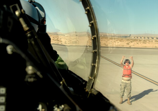 Senior Airman Ben Teats, weapons specialist, marshalls in F-16 pilot Capt. Thomas Tauer, August 20, 2008, during exercise Green Flag 08-09 at Nellis Air Force Base, Nev. This training prepares U.S. and allied forces to fight in a high-tech combat environment while providing Air Force leaders valuable planning experience.  Green Flag provides world class close air support counter land airpower training for Air Force, sister services, and international combat fighter, bomber, and airborne command and control squadrons stressing realistic combat environments focused on high desert armored warfare.  The exercise facilitates joint operational training at the U.S. Army National Training Center at Fort Irwin, Calif.  Senior Airman Teats and Capt. Tauer are both assigned to the 13th Fighter Squadron, Misawa Air Base, Japan.
(U.S. Air Force photo/ Master Sgt. Kevin J. Gruenwald)