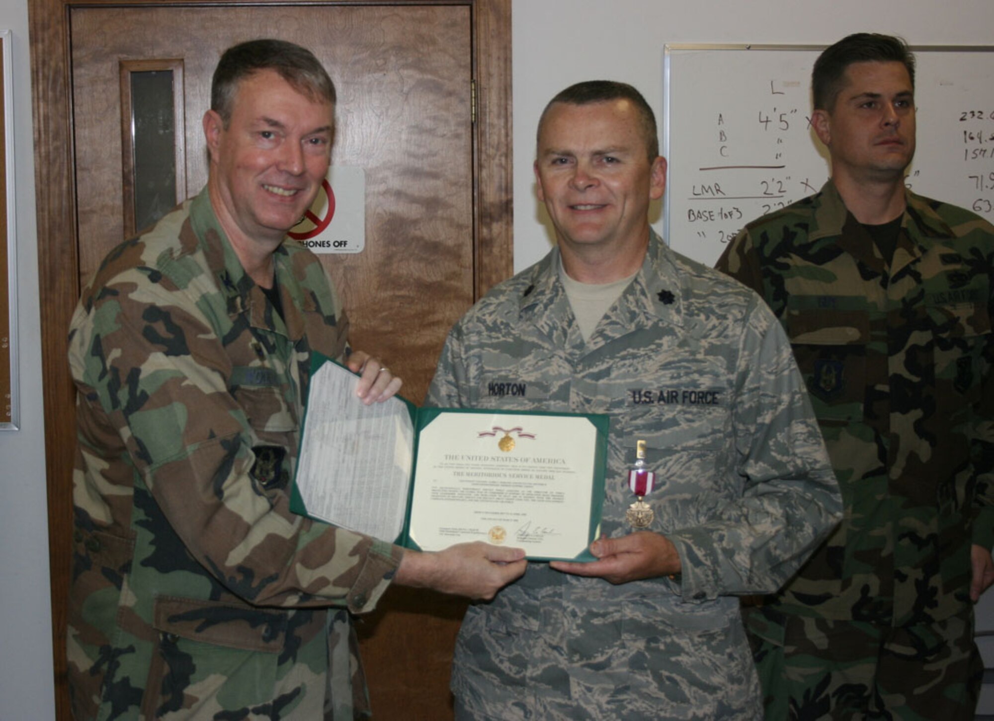 SEYMOUR JOHNSON AIR FORCE BASE, N.C. -- Lt. Col. James Horton (right) receives the Air Force Meritorious Service Medal from Col. Woody Woodson, 916th Mission Support Group commander for his efforts during Operation Iraqi Freedom. Col. Horton is the commander for the 916th Communications Squadron.