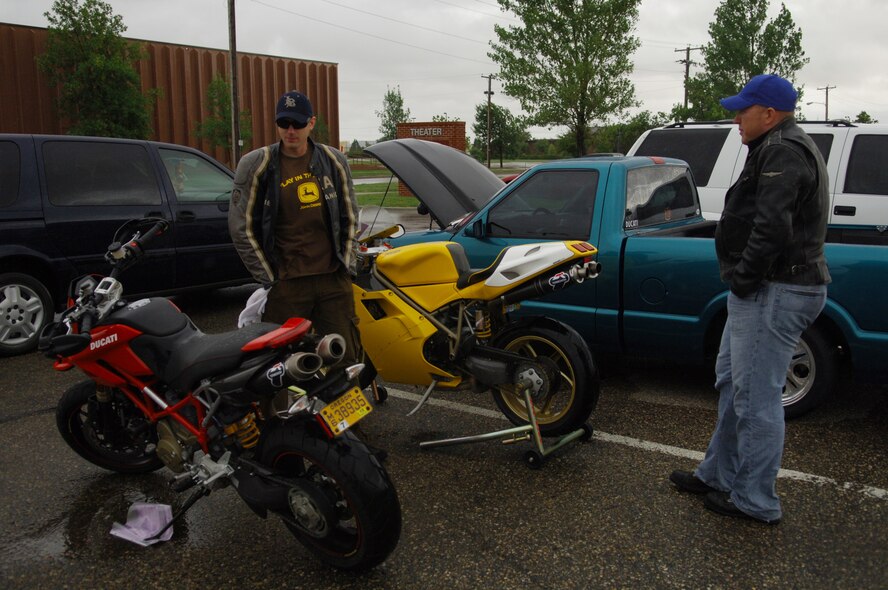 MINOT AIR FORCE BASE, N.D. – Staff Sgt. Sam Brandt, 5th Aircraft Maintenance Squadron unit training monitor, and 1st Lt. Brad Beckwith, 742nd Missile Squadron ICBM combat crew deputy commander, look at the motorcycles during the car show at J.R. Rockers here Aug. 22. Along with the motorcycles, there were 18 cars and trucks on display outside and raffles and a hula-hoop contest held inside. (U.S. Air Force photo by Senior Airman Cassandra Jones)