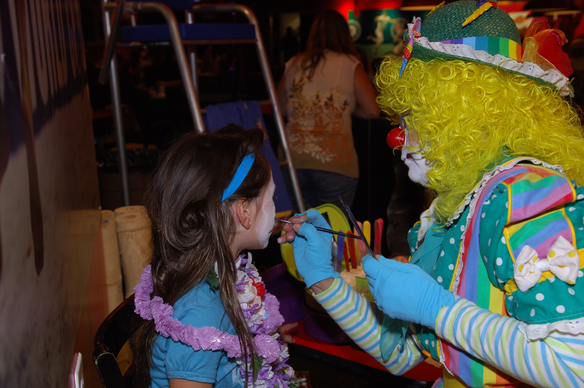 MINOT AIR FORCE BASE, N.D. – Although it rained outside there were no dampened spirits during the Luau at the Rock/Show and Shine car show held at J.R. Rockers here Aug. 22. During the festivities, Cloudy the Clown painted a cat face on Trinity Bauer, daughter of Tech. Sgt. Patrick Bauer, 5th Communications Squadron. Along with the motorcycles, cars and trucks on display outside, there were raffles and a hula-hoop contest held inside. (U.S. Air Force photo by Senior Airman Cassandra Jones)