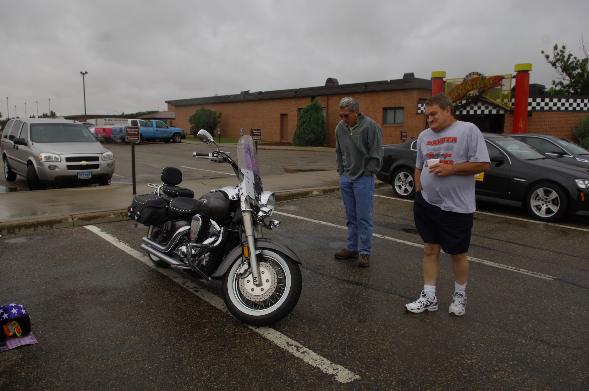 MINOT AIR FORCE BASE, N.D. – Kevin Bauer, 5th Medical Support Squadron utilization manager, and Al Johnson, Minot Chamber of Commerce, look at one of the four motorcycles brought to the Show and Shine car show at J.R. Rockers here Aug. 22. Along with the motorcycles, there were 18 cars and trucks on display outside and raffles and a hula-hoop contest held inside. (U.S. Air Force photo by Senior Airman Cassandra Jones)