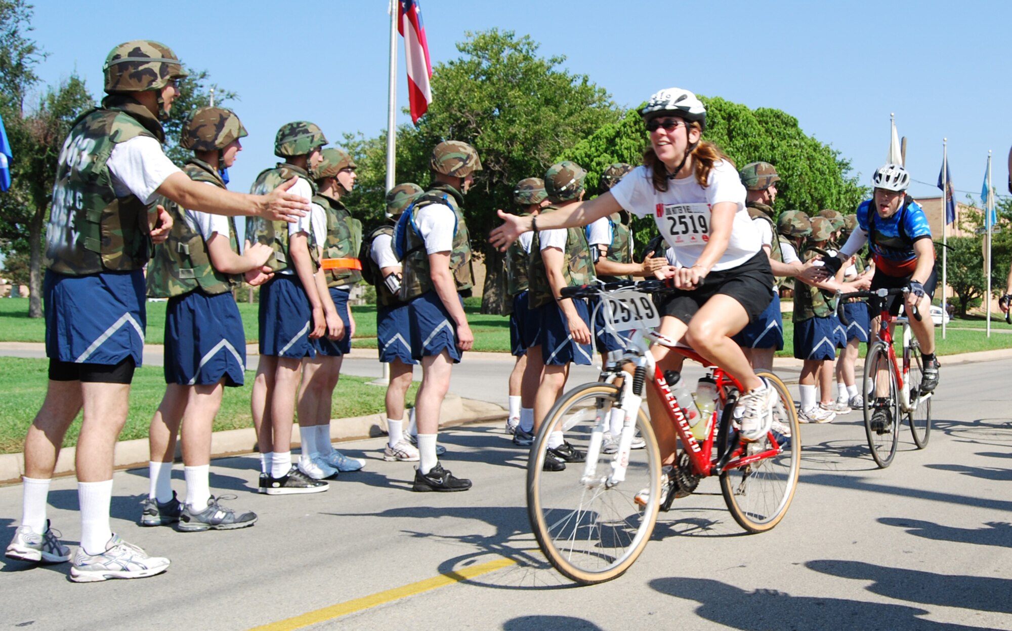 Members of the 363rd Training Squadron encourage and cheer participants in the 27th Annual Hotter'N Hell Hundred race as they pass through Sheppard Air Force Base Aug. 25. Over 12,000 cyclists participated in the race. (U.S. Air Force photo/Airman 1st Class Candy Miller)