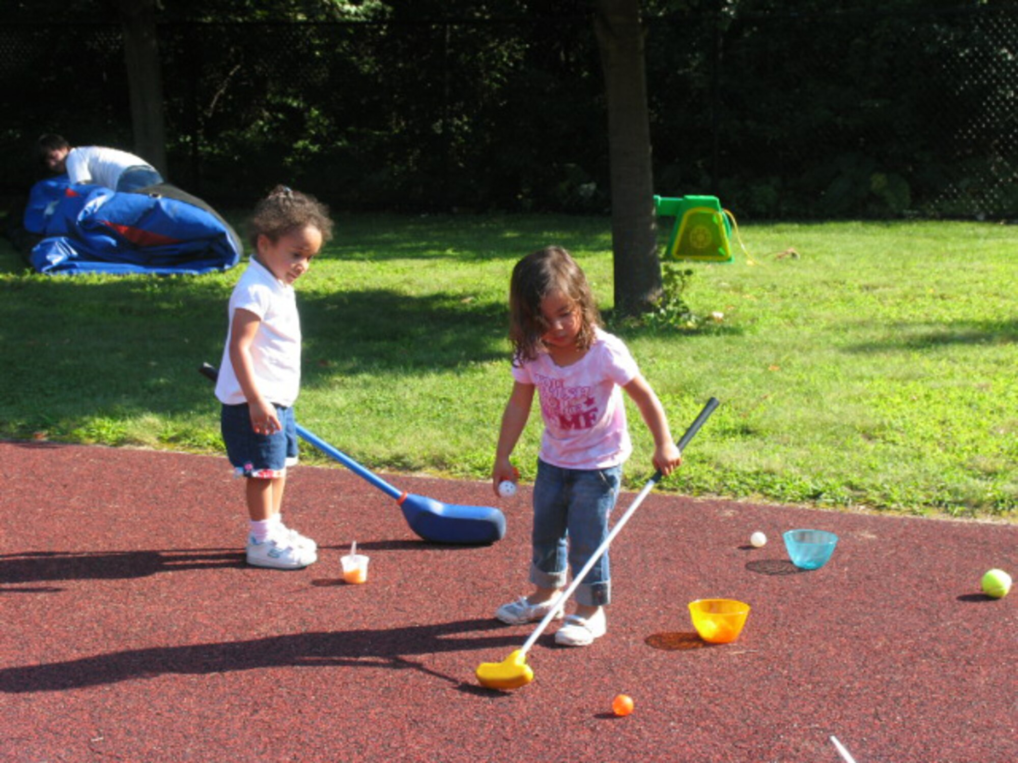 HANSCOM AFB, Mass. – Genesis Sandoval (left) and Haley Poblete (right) try out a golf game at the Child Development Center’s Summer Carnival on Aug. 22. The carnival offered an opportunity for children to participate in a number of activities such as face painting, games, crafts and a bouncy castle with their parents and caregivers. (U.S. Air Force photo by Rhonda Siciliano)