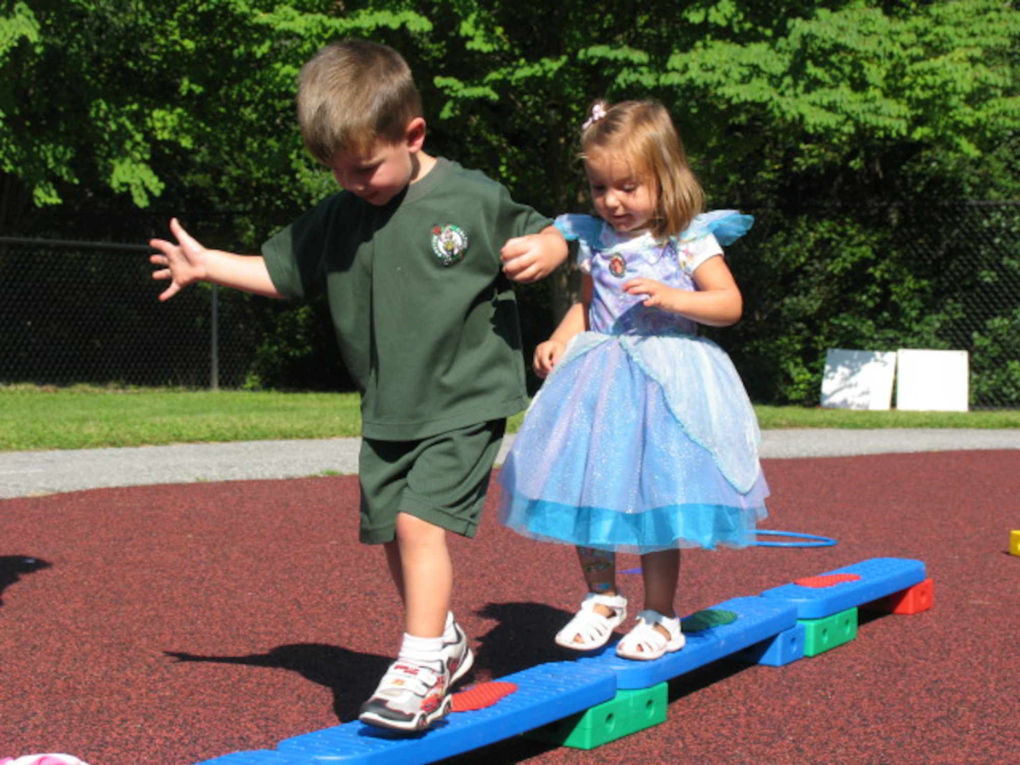 HANSCOM AFB, Mass. – Ethan Thorp (left), and Alexis Melvin (right), test their balancing skills during the Child Development Center’s Summer Carnival on Aug. 22 outside the CDC. The fair included a bouncy castle, face painting and a variety of games for the children, caregivers and parents to participate in. (U.S. Air Force photo by Rhonda Siciliano)