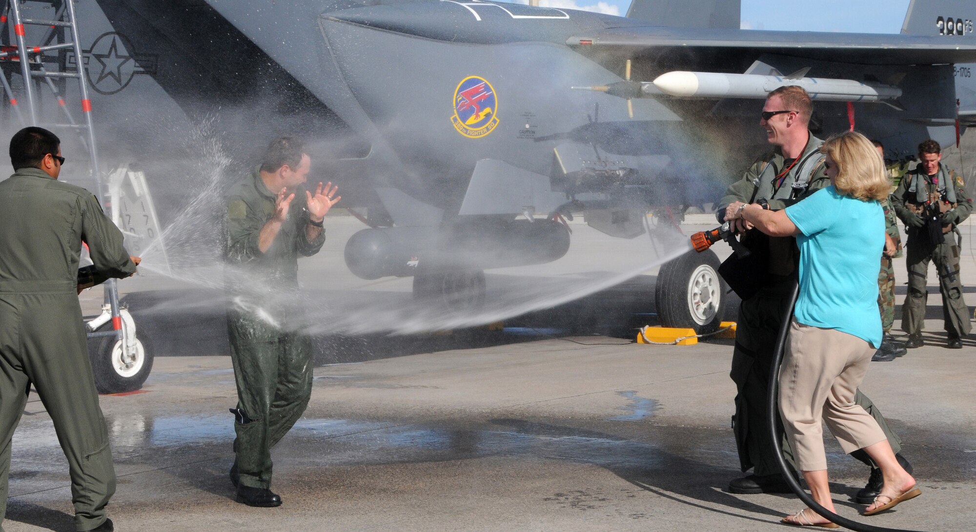 ANDERSEN AIR FORCE BASE, Guam - Brig. Gen. Doug Owens, 36th Wing commander, tries to avoid being sprayed with water by his wife Teresa and members of the 389th Fighter Squadron after his final flight here Aug. 26. During General Owens' time here, he helped pave the way for the Marine Corps move from Okinawa to Guam. After relinquishing command of the 36th WG Sept. 2, he will move on to his new assignment at Hickam AFB, Hawaii. (U.S. Air Force photo by Airman 1st Class Courtney Witt)