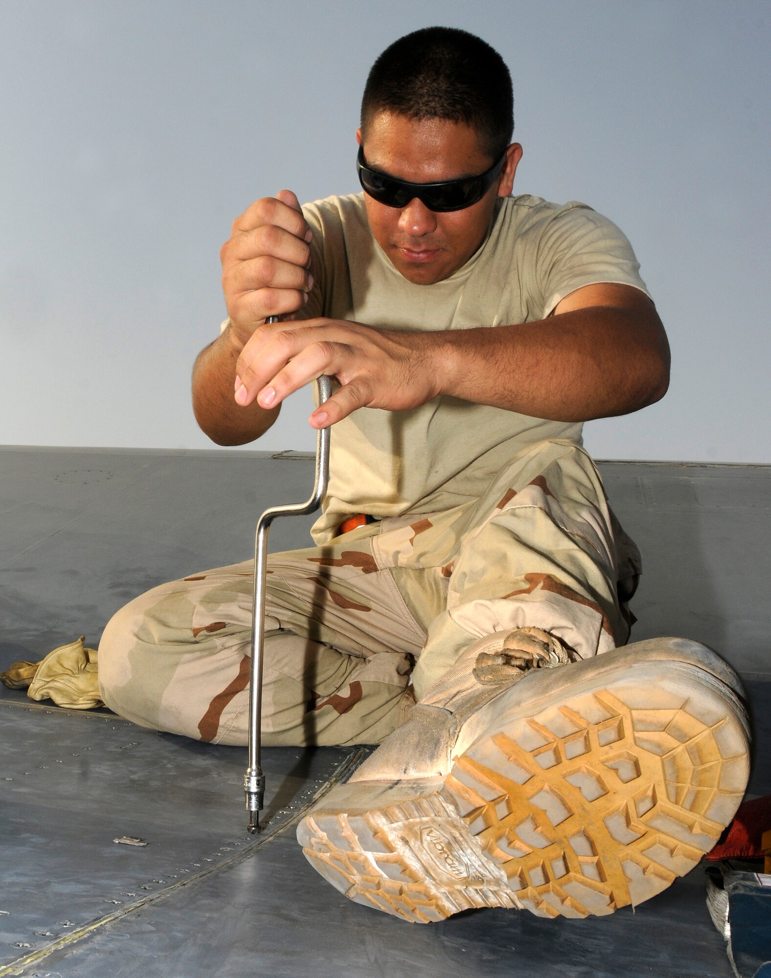 Airman 1st Class Jonathan Quintanilla, a crew chief assigned to the 379th Expeditionary Aircraft Maintenance Squadron, 34th Aircraft Maintenance Unit, tightens rivets on a gear screw access panel Aug. 25, 2008 at an undisclosed air base in Southwest Asia.  The access panel was removed to allow a check of the gear sweep assembly as part of a home station check.  Home station checks are performed every 800 hours of flying time, checking wear and chafing in high stress sections of the B-1 Lancer aircraft.  B-1s assigned to the 379th are regularly called upon for precision air strikes in support of Operations Iraqi Freedom and Enduring Freedom.  Airman Quintanilla is a native of Agat, Guam and is deployed from Ellsworth Air Force Base, S.D.  (U.S. Air Force photo by Tech. Sgt. Michael Boquette/Released)
