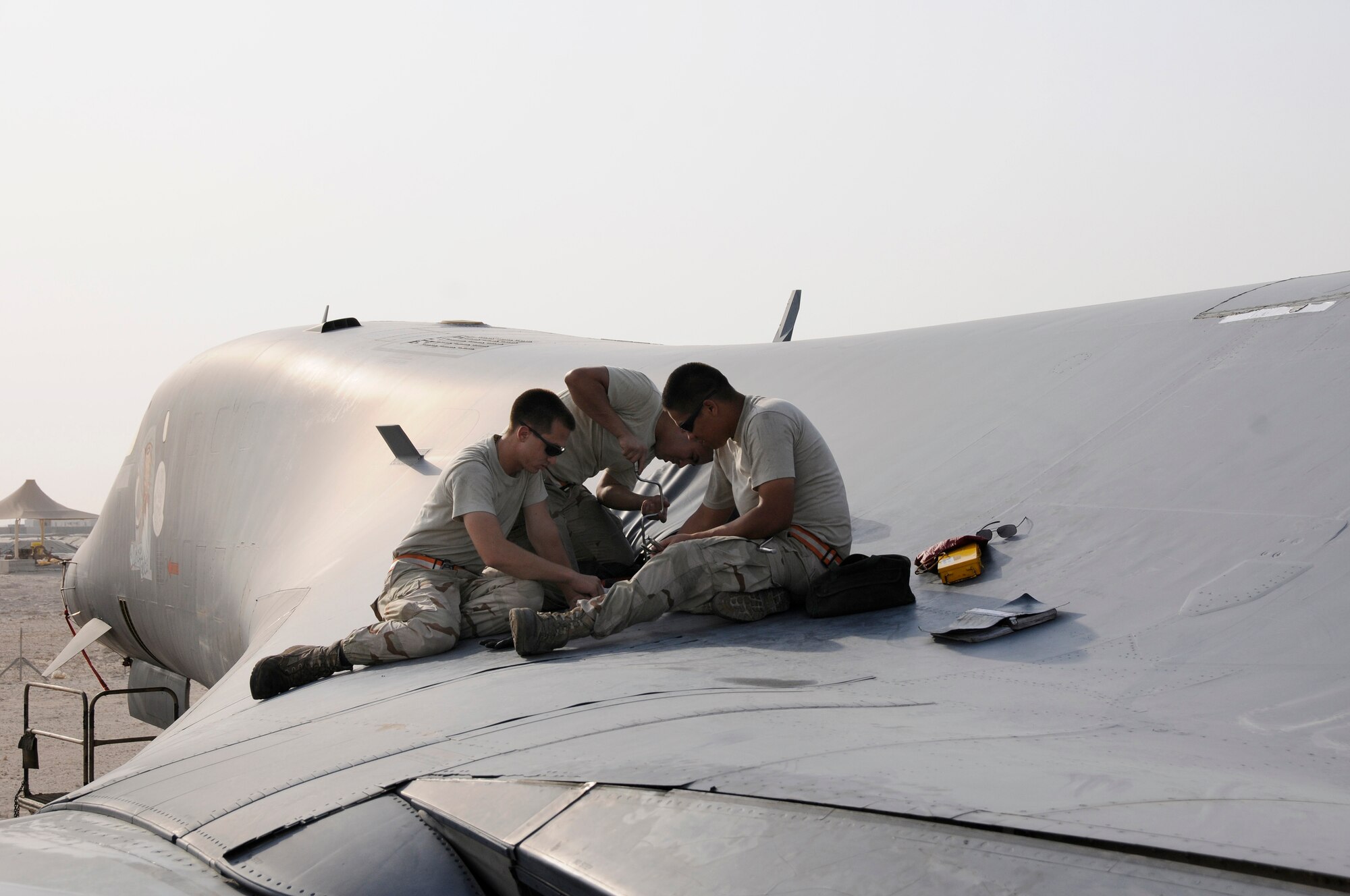 Airman 1st Class Brian Decker, Airman 1st Class Pablo Fajardo, and Airman 1st Class Jonathan Quintanilla, all crew chiefs with the 379th Expeditionary Aircraft Maintenance Squadron, 34th Aircraft Maintenance Unit, tighten rivets on a gear screw access panel Aug. 25, 2008 at an undisclosed air base in Southwest Asia.  The access panel was removed to allow a check of the gear sweep assembly as part of a home station check.  Home station checks are performed every 800 hours of flying time, checking wear and chafing in high stress sections of the B-1 Lancer aircraft.  B-1s assigned to the 379th are regularly called upon for precision air strikes in support of Operations Iraqi Freedom and Enduring Freedom.  Airman Quintanilla is from Agat, Guam, Airman Fajardo is a native of Brooklyn, N.Y., and Airman Decker hails from Murphy, N.C. All are deployed from Ellsworth Air Force Base, S.D.  (U.S. Air Force photo by Tech. Sgt. Michael Boquette/Released)