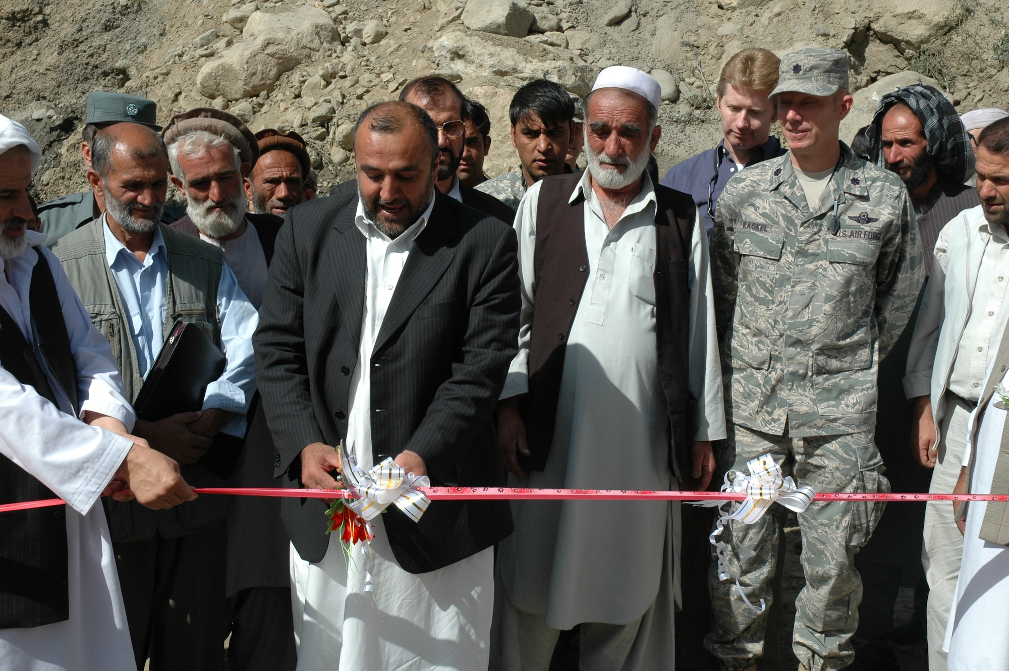 Panjshir Provincial Governor Hajji Bahlol cuts the ribbon at the groundbreaking ceremony for the new $179,000 Bakshikhiel Bridge in Rokha District, Panjshir on Aug 24.  The Bakshikhiel Bridge was one of two in Rokha that were destroyed by the floods in June 2007 killing 23 people.  “The people of Rokha District have been through a great deal,” said Air Force Lt. Col. Russell Kaskel, Panjshir Provincial Team’s Commander (pictured here).  “By some accounts, the number of deaths on 27 June 2007 was the most experienced in one day since the Russians stopped fighting in Panjshir.  So, you can understand why this project is so well received.” The bridge is scheduled to be complete in November, hopefully before the first snow. (U.S. Air Force photo by Capt. Jillian Torango/Released)