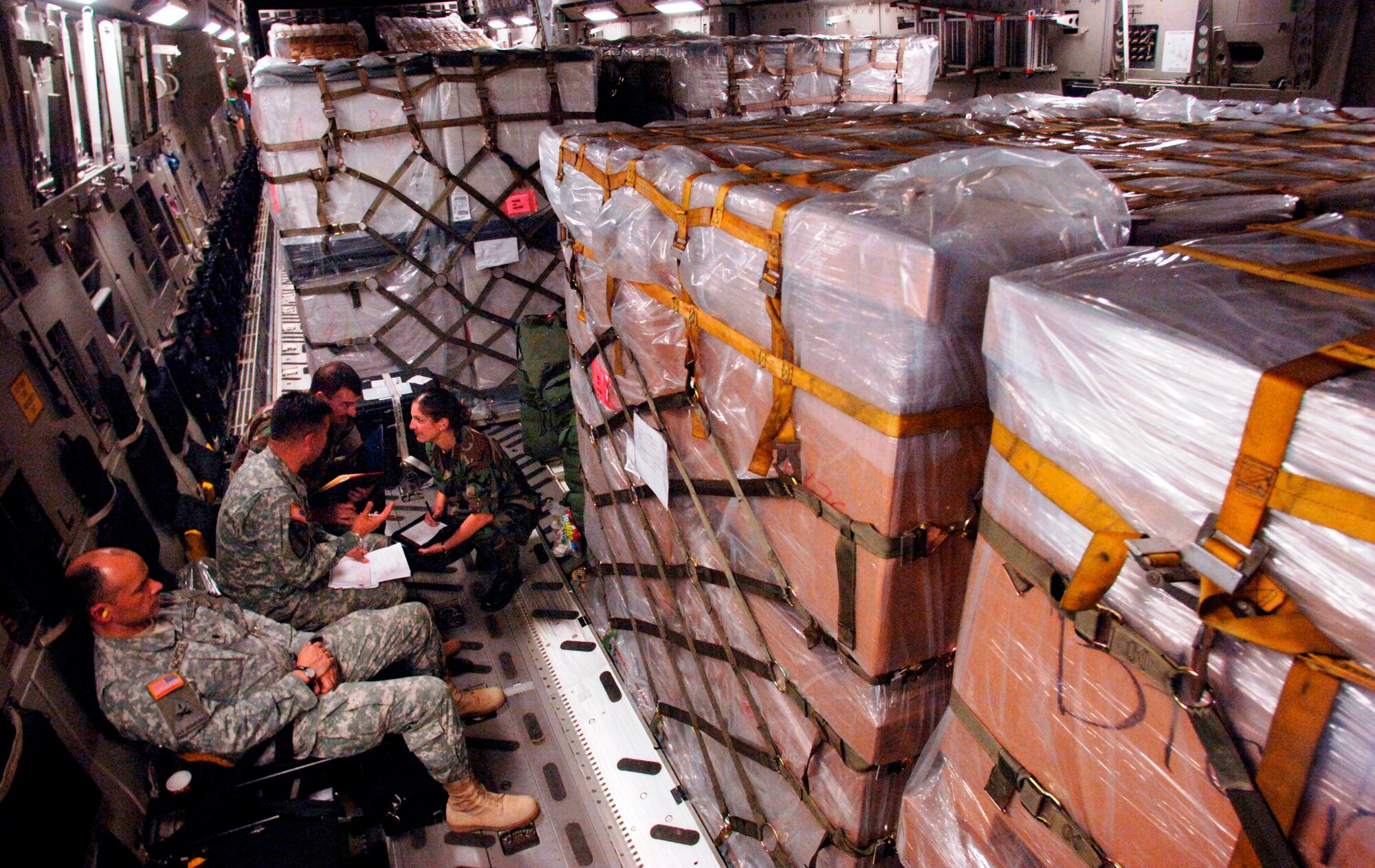 While en route to Tbilisi, Georgia, from Ramstein Air Base, Germany, a small group of U.S. Army, Navy and Air Force officers discuss details of the joint humanitarian assistance delivery.  The delivery consisted of $1M in U.S.-donated medical supplies, blankets, sleeping bags and bed sheets for the people of the Republic of Georgia. 
(Air Force Photo by Master Sgt. Scott Wagers / AFNEWS)(Released)