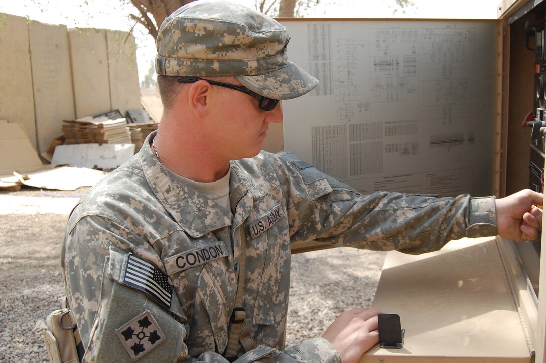 Army Cpl. Jack Condon works on a generator as part of his daily routine on Camp Taji, Iraq, Aug. 22, 2008. U.S. Army photo by Sgt. 1st Class Brent Hunt, Multinational Division Baghdad