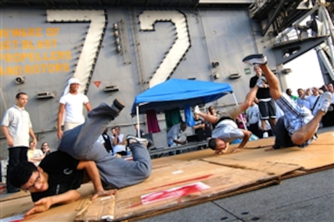 U.S. Navy sailors break dance on the flight deck during a steel beach picnic aboard the aircraft carrier USS Abraham Lincoln in the North Arabian Sea, Aug. 14, 2008. 
