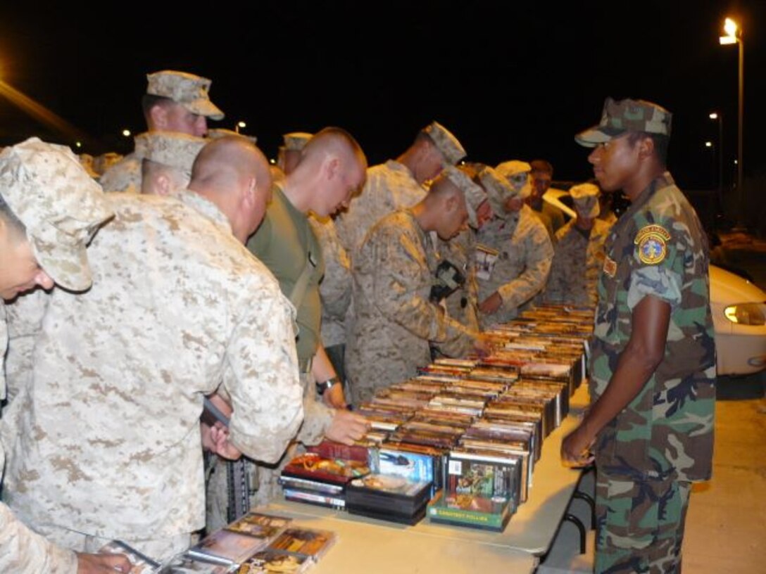 Marines from 3rd Battalion, 7th Marine Regiment look through a selection of DVDs offered by the Temecula Valley Young Marines Sept. 27 at the Combat Center’s Unit Marshalling Area before deploying to Iraq.