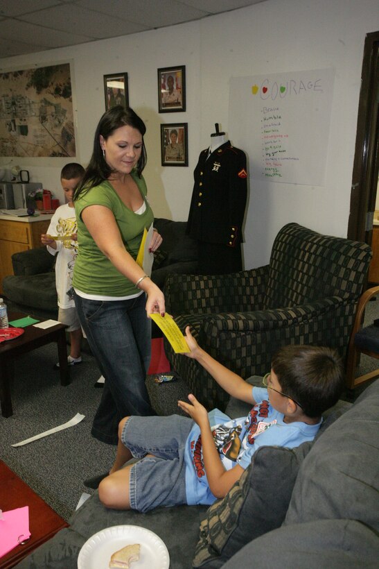 Katrina Pride, a L.I.N.K.S. staff member, hands paper cutouts to the children to make a paper chain of their names during the first Kid’s L.I.N.K.S. session at the Kid’s L.I.N.K.S. building Aug. 27.  This was the first L.I.N.K.S. for Kid’s session and marks the beginning of an entirely new series of L.I.N.K.S. programs aimed not only at spouses, but also at children, parents of service members and service members themselves.