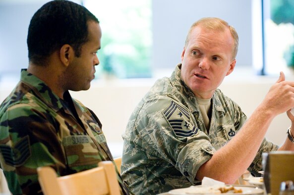 Tech. Sgt. Damien Slaughter, 446th Aircraft Maintenance Squadron, talks with Command Chief Master Sgt. James Cody, 18th Air Force command chief, at the Olympic Dining Facility here Aug. 27. (U.S. Air Force photo/Abner Guzman) 
