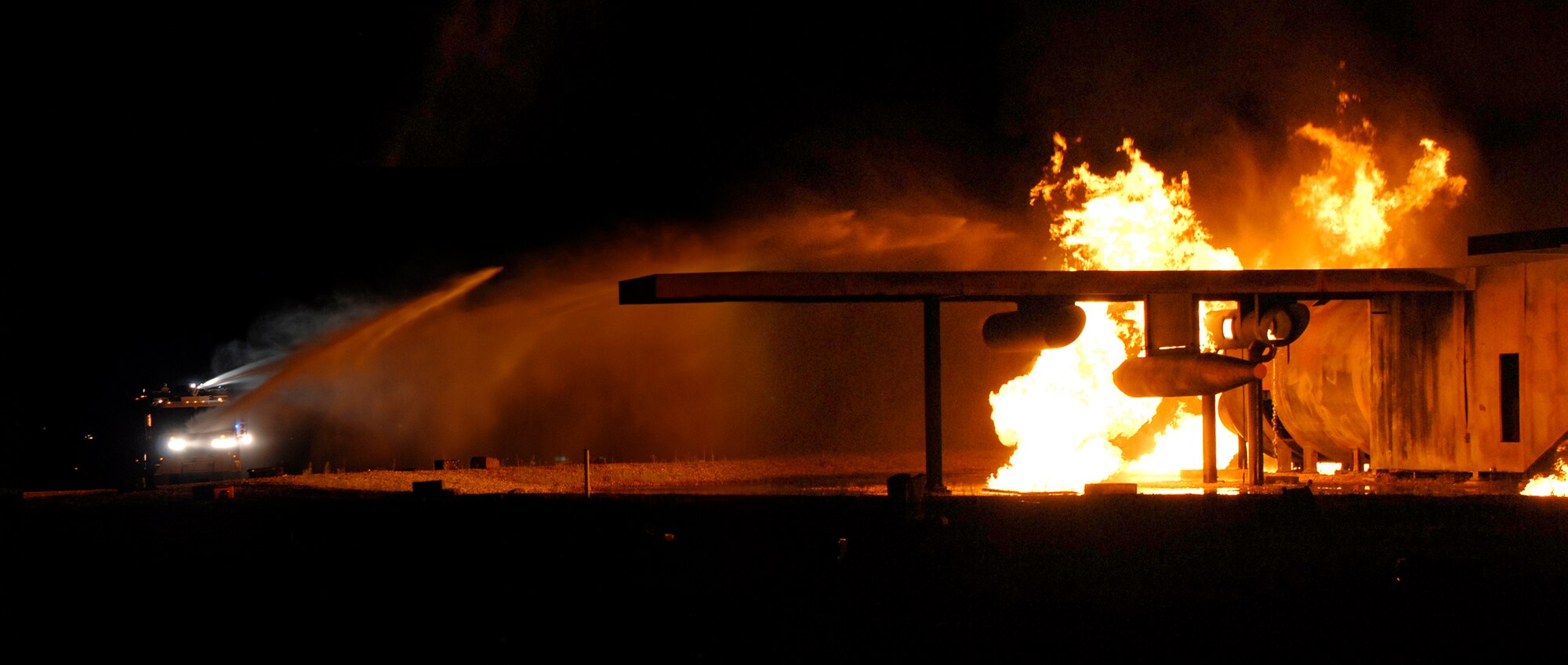 Firefighters assigned to the 21st Civil Engineer Squadron fire protection flight battle a simulated cargo aircraft fire Aug. 18 during Condor Crest 08-05 events at Peterson Air Force Base, Colo. The week-long exercise encompassed several scenarios that challenged Airmen. The scenarios included an intruder on base, severe weather inflicted damage on the base and simulated aircraft accidents. (U.S. Air Force photo/Craig Denton)