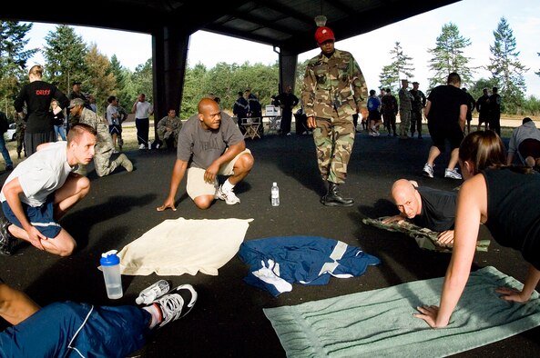 Members of the 62nd Aircraft Maintenance Squadron, perform push-ups during a Red Cross fundraiser sponsored by the First Sergeant Council. (U.S. Air Force photo/Abner Guzman)